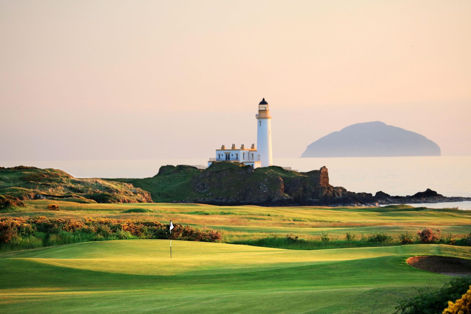 Panoramic view of the Trump Turnberry Resort course with a lighthouse in the distance