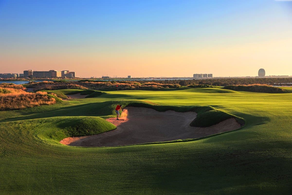 A smooth green next to a deep sand bunker