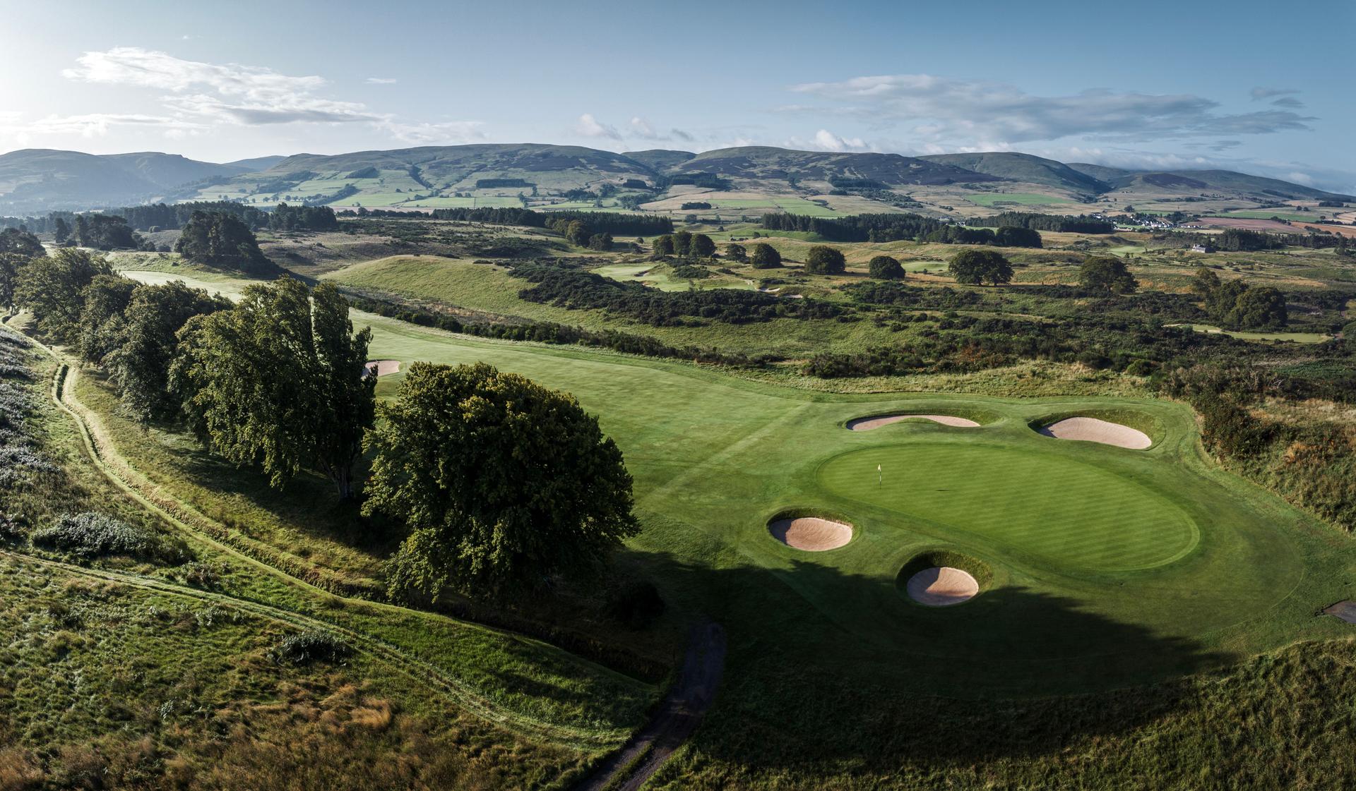A well maintained fairway leading to a smooth green surrounded by sand bunkers
