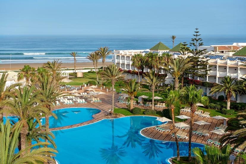 Overhead view of the outdoor swimming pool at Iberostar Founty surrounded by palm trees with beach views