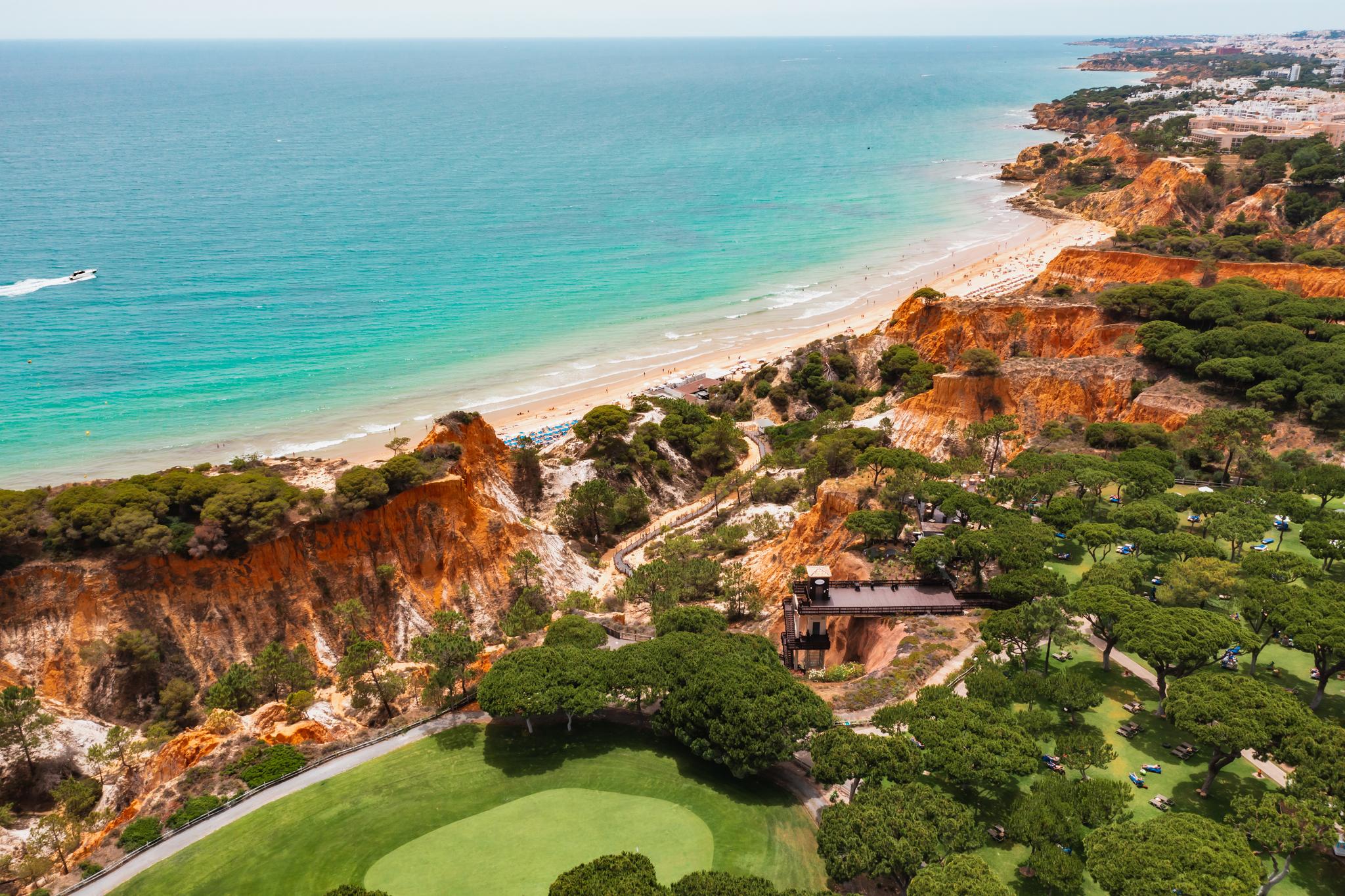 Aerial view of a smooth hilltop green with coastal views at Pine Cliffs Resort