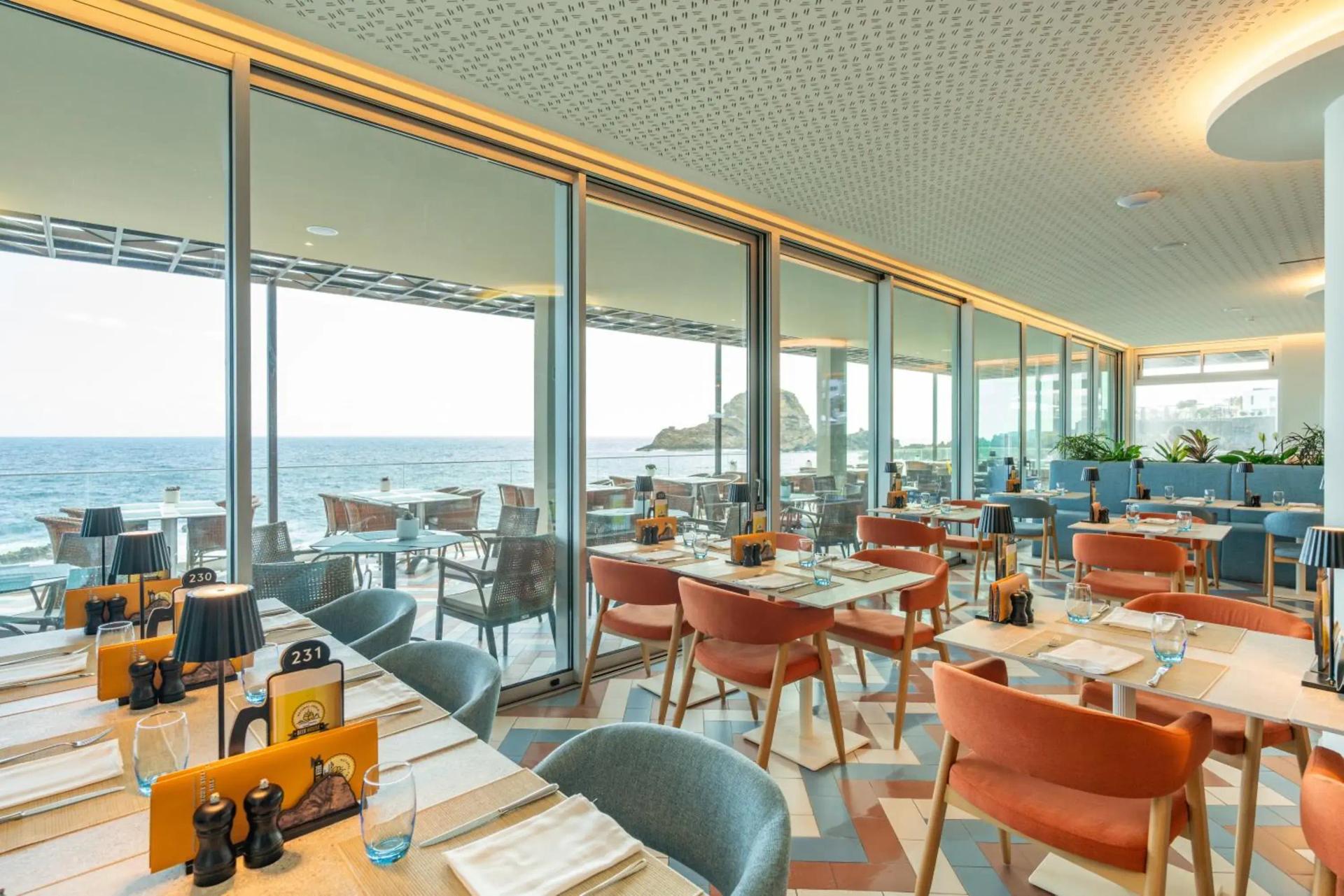 Indoor dining with coastal views at Aqua Natura Bay