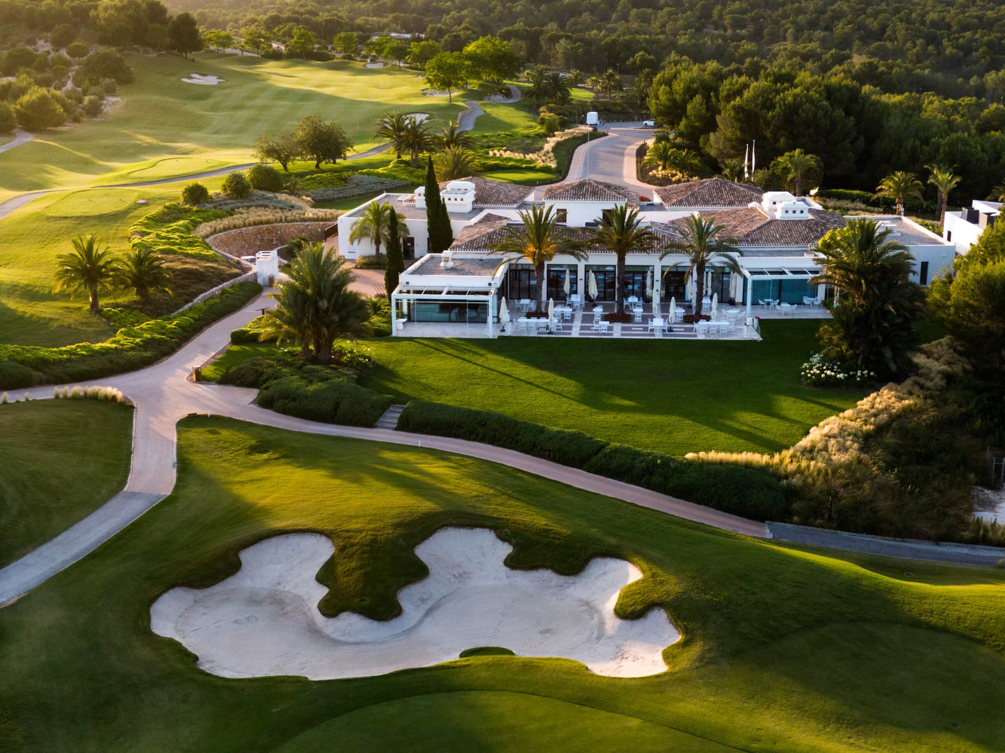 Overhead view of a villa overlooking a sand bunker on a fairway just outside