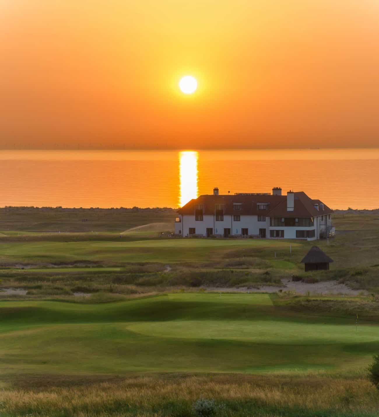 Panoramic view of the sun setting over Prince's Golf Club