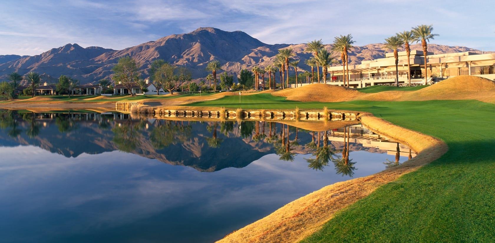 A manicured fairway leading to a smooth green next to a water hazard