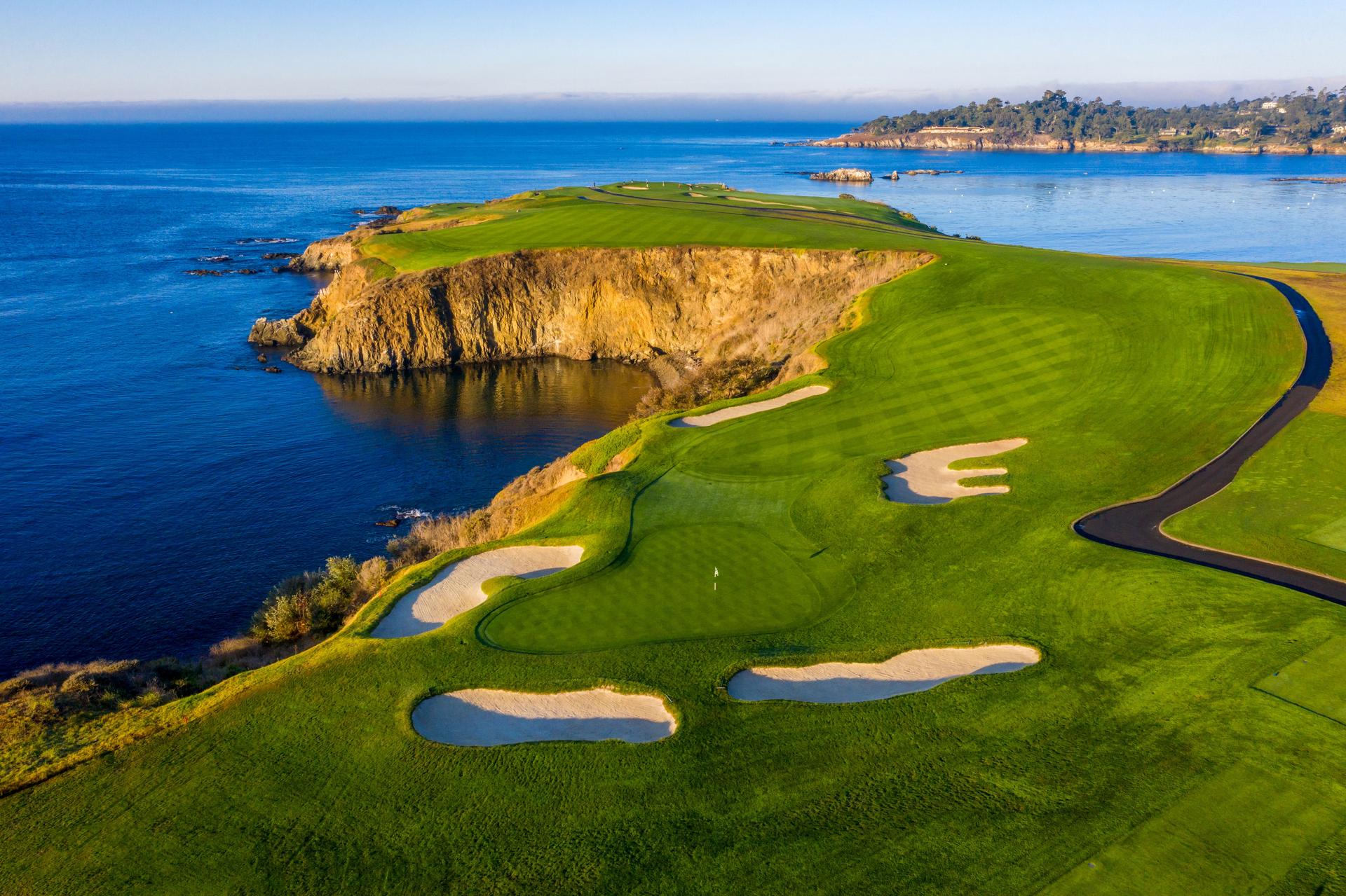 Overhead view of a well maintained fairway leading to a smooth green surrounded by sand bunkers