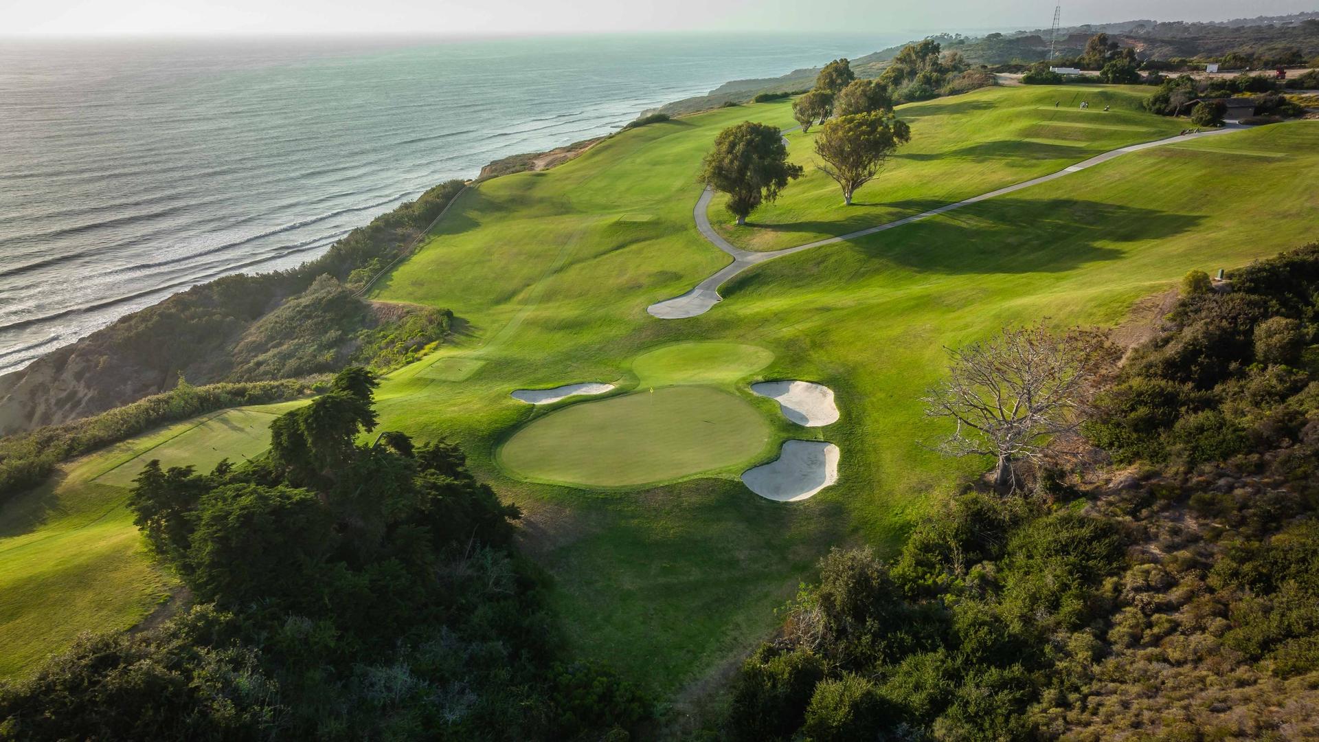 A well maintained fairway leading to a smooth green surrounded by sand bunkers