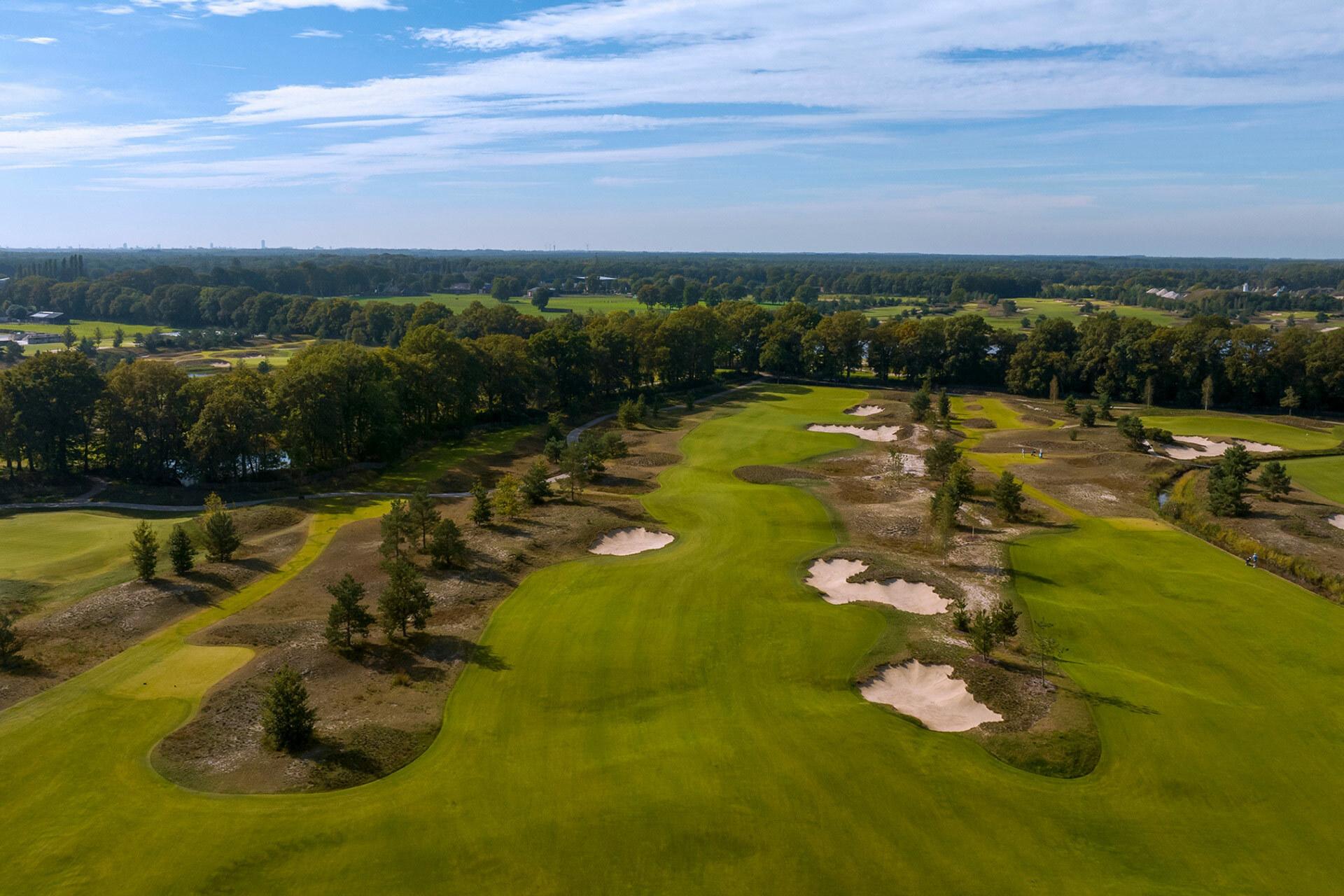 A well maintained fairway littered with sand bunkers