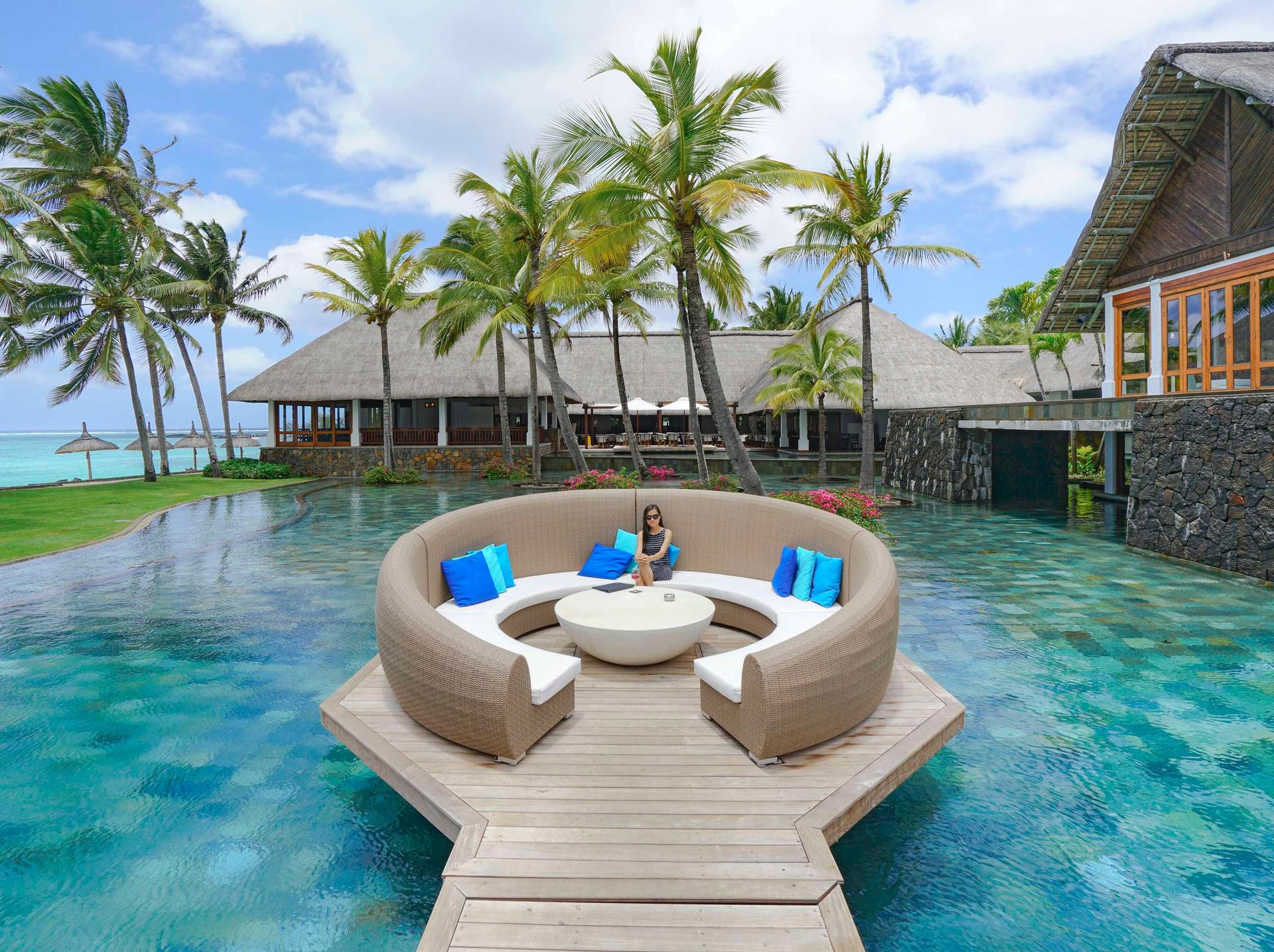 Outdoor seating area above water at Constance Belle Mare Plage