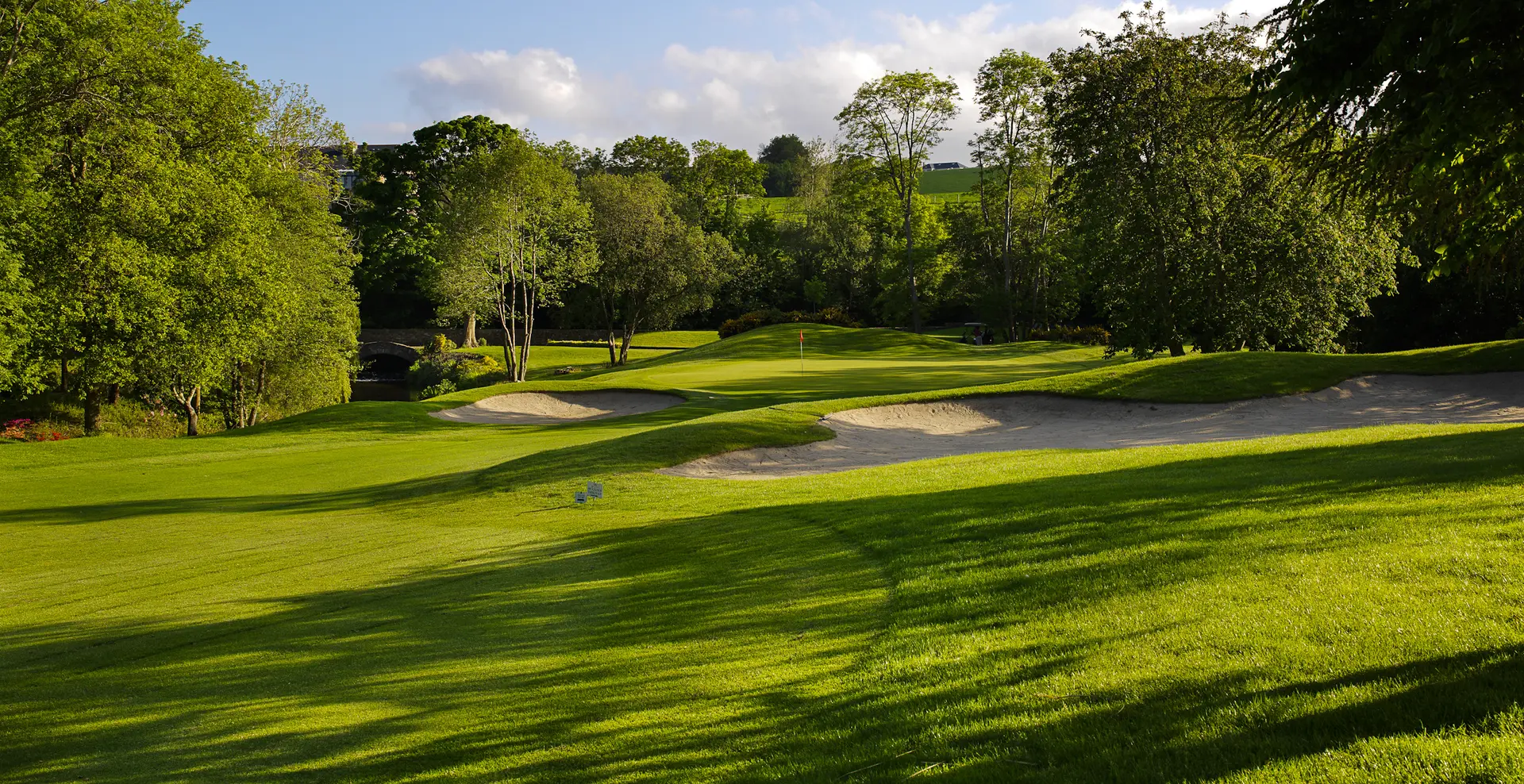A well maintained fairway nestled with sand bunkers
