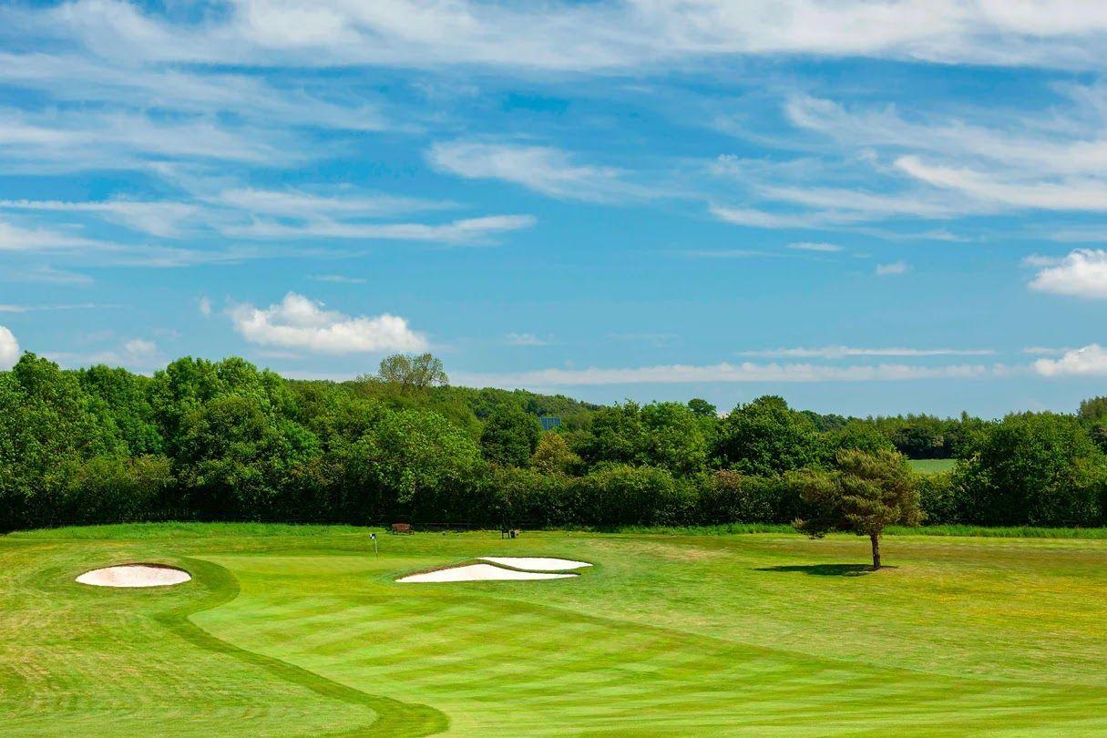 A wide fairway nestled with sand bunkers