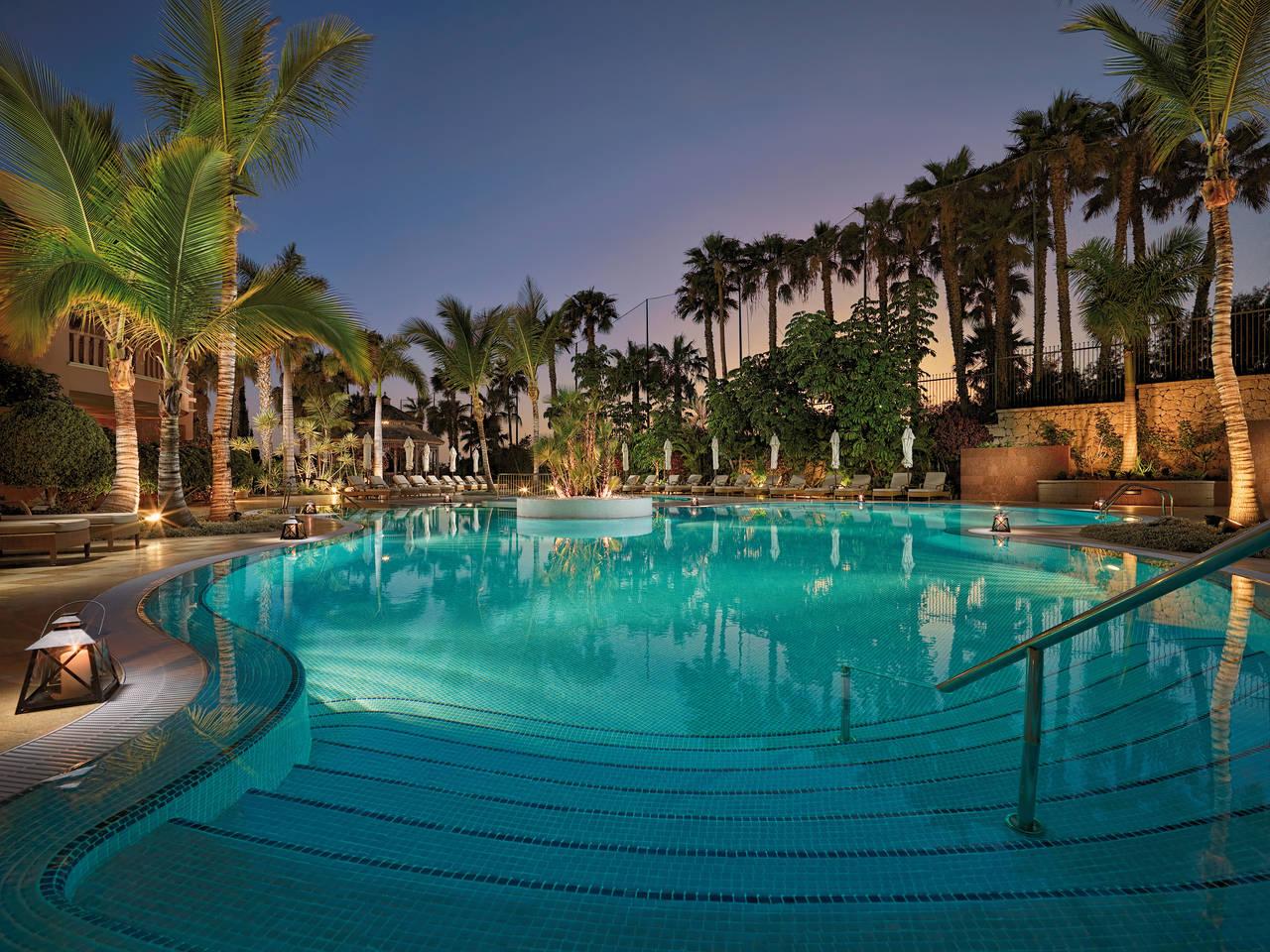 Outdoor pool area surrounded by palm trees