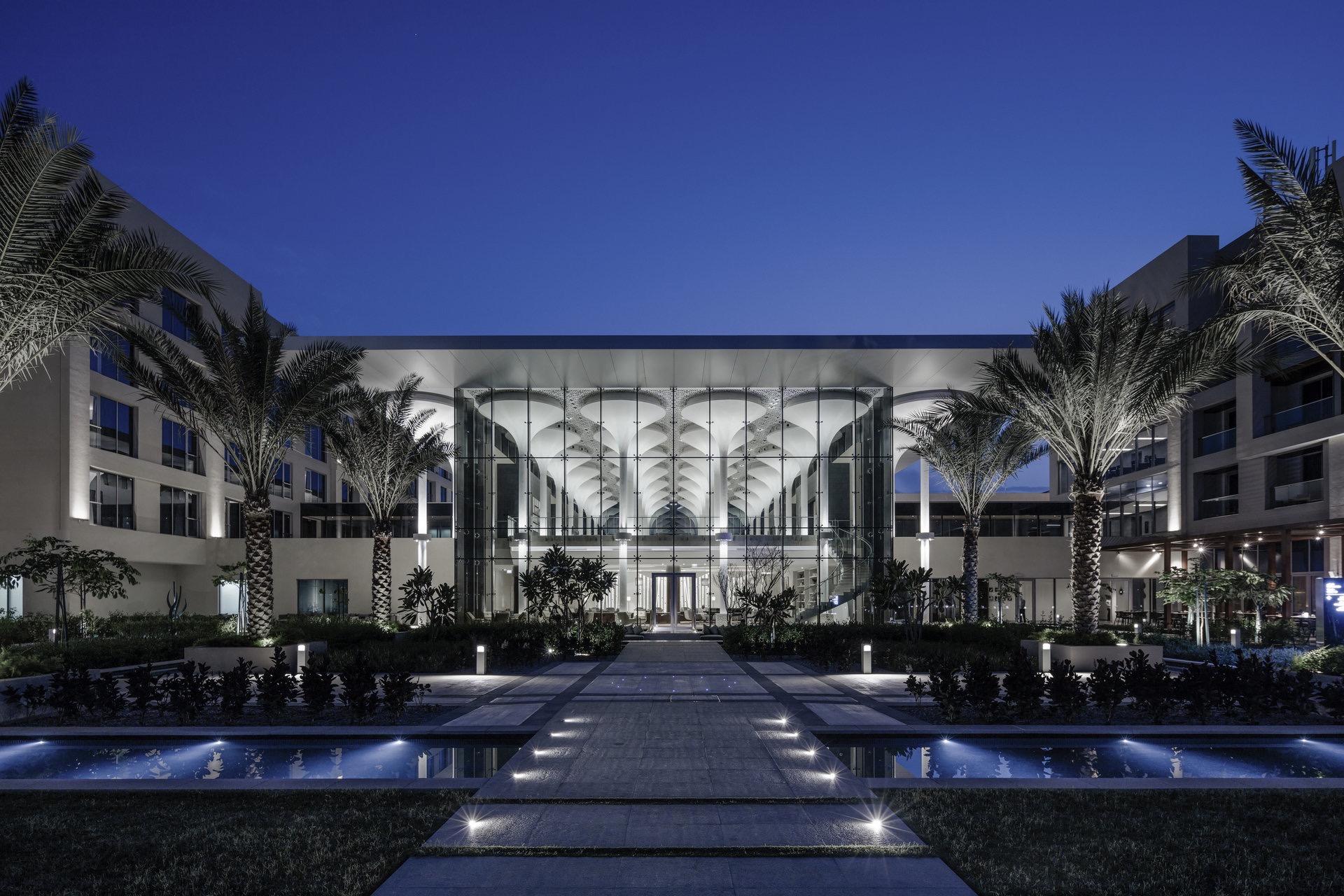 A walkway leading towards the hotel lit up at night time