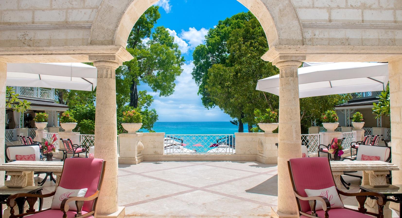 Outdoor dining area with views of the ocean at Sandy Lane