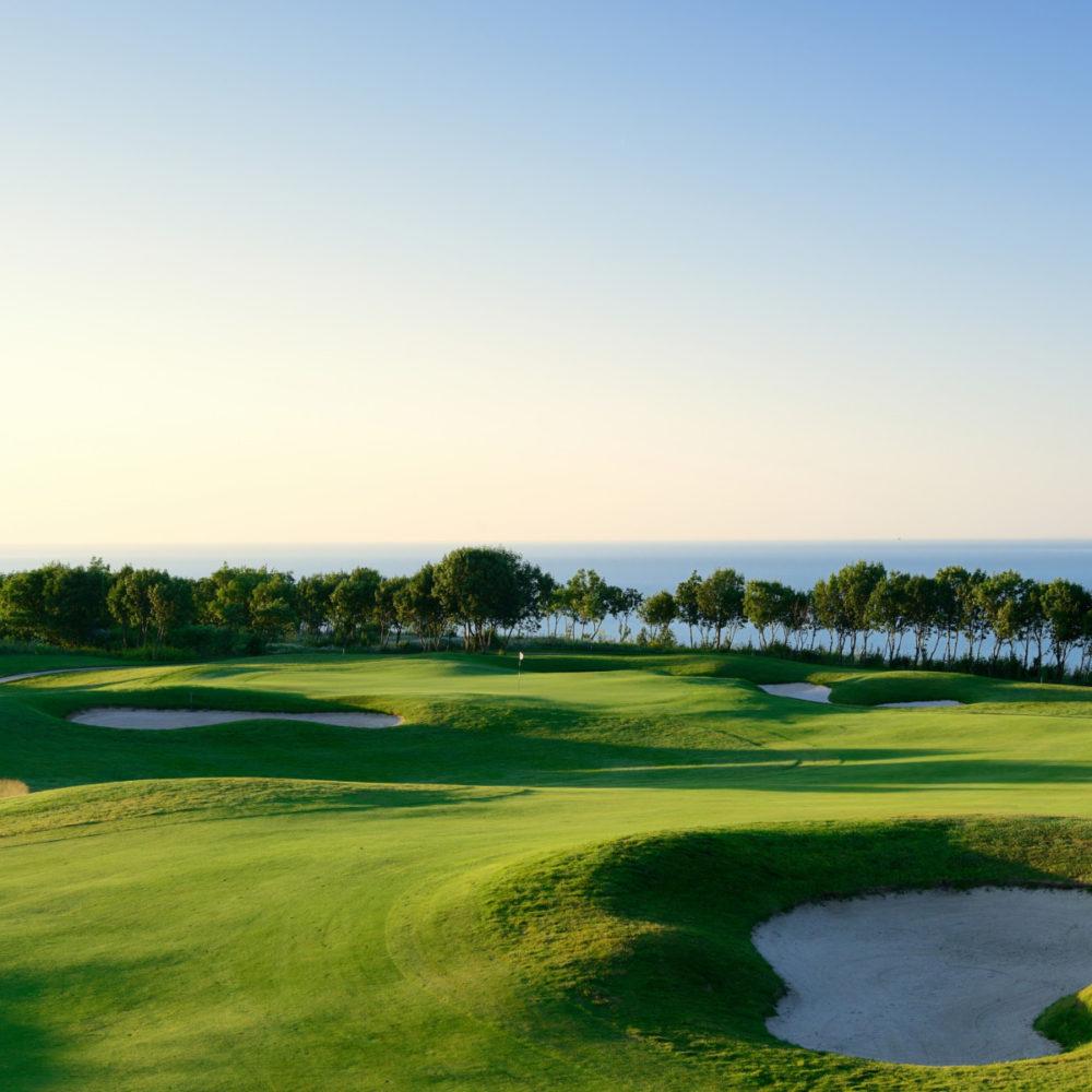 A well maintained fairway nestled with sand bunkers