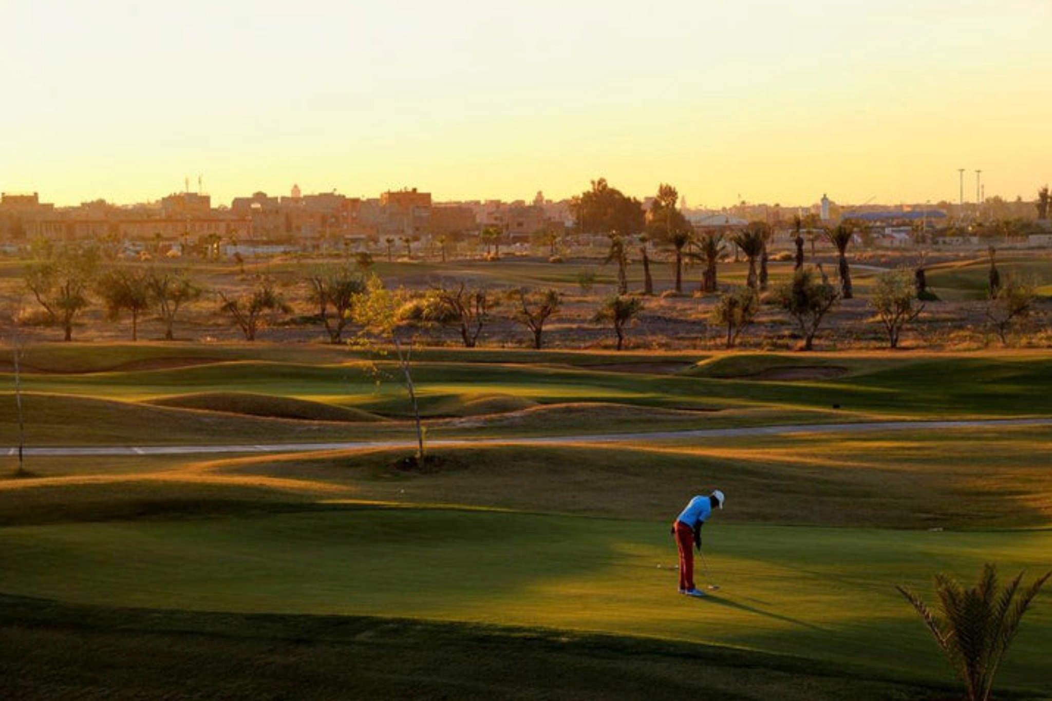 Golfer on a well maintained fairway at sunset