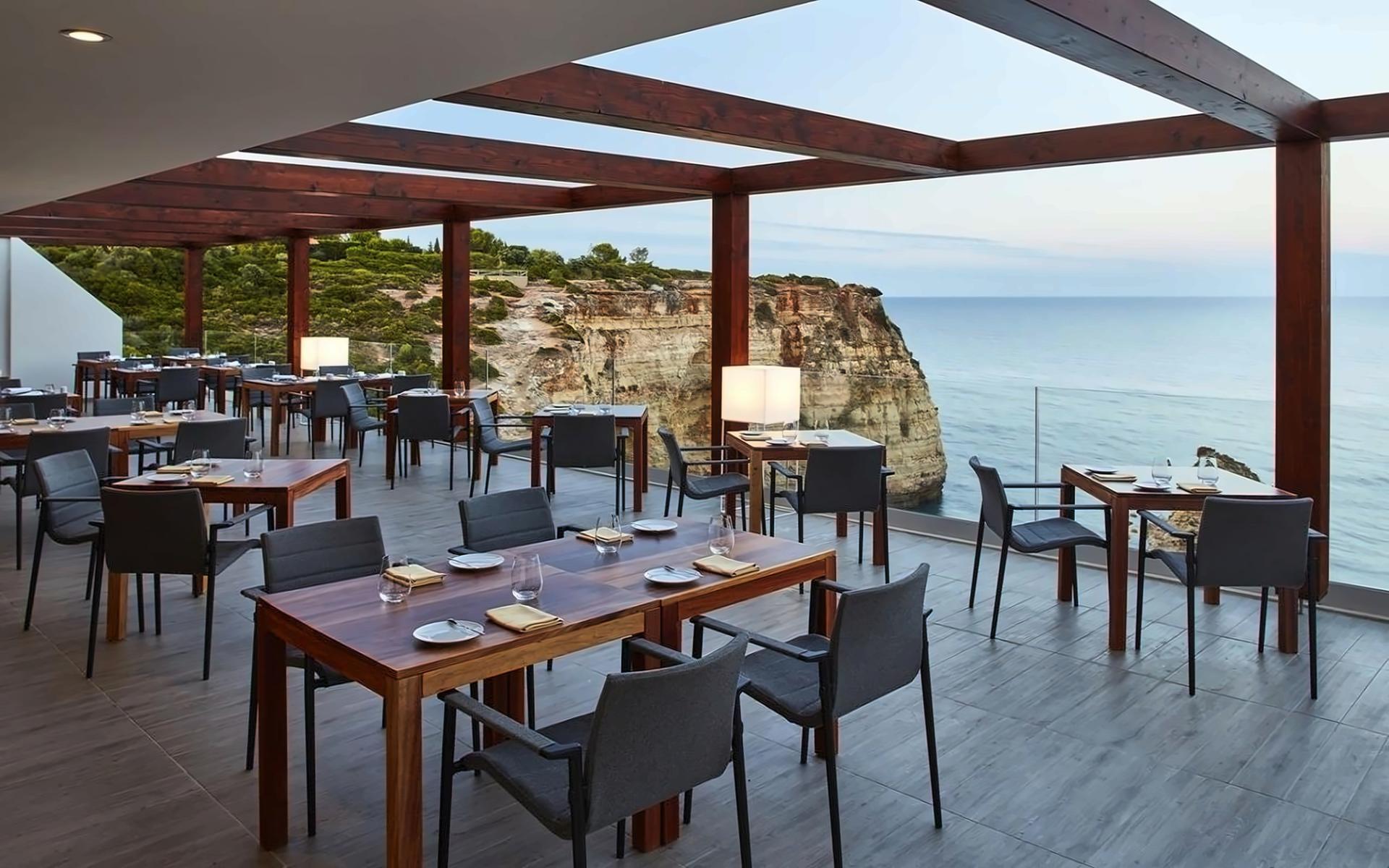 Outdoor dining area at the Tivoli Carvoeiro with coastal views