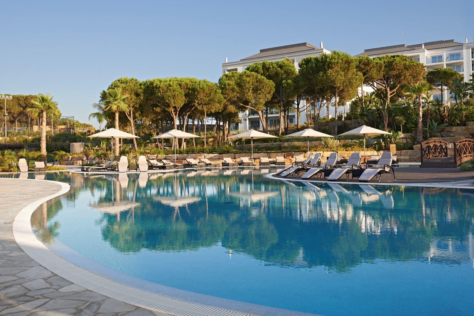 Outdoor swimming pool surrounded by sunbeds