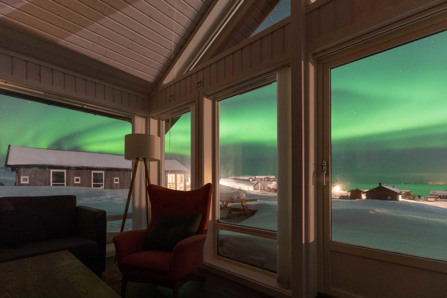 Living room as part of a lodge at Lofoten Links with the northern light in the window