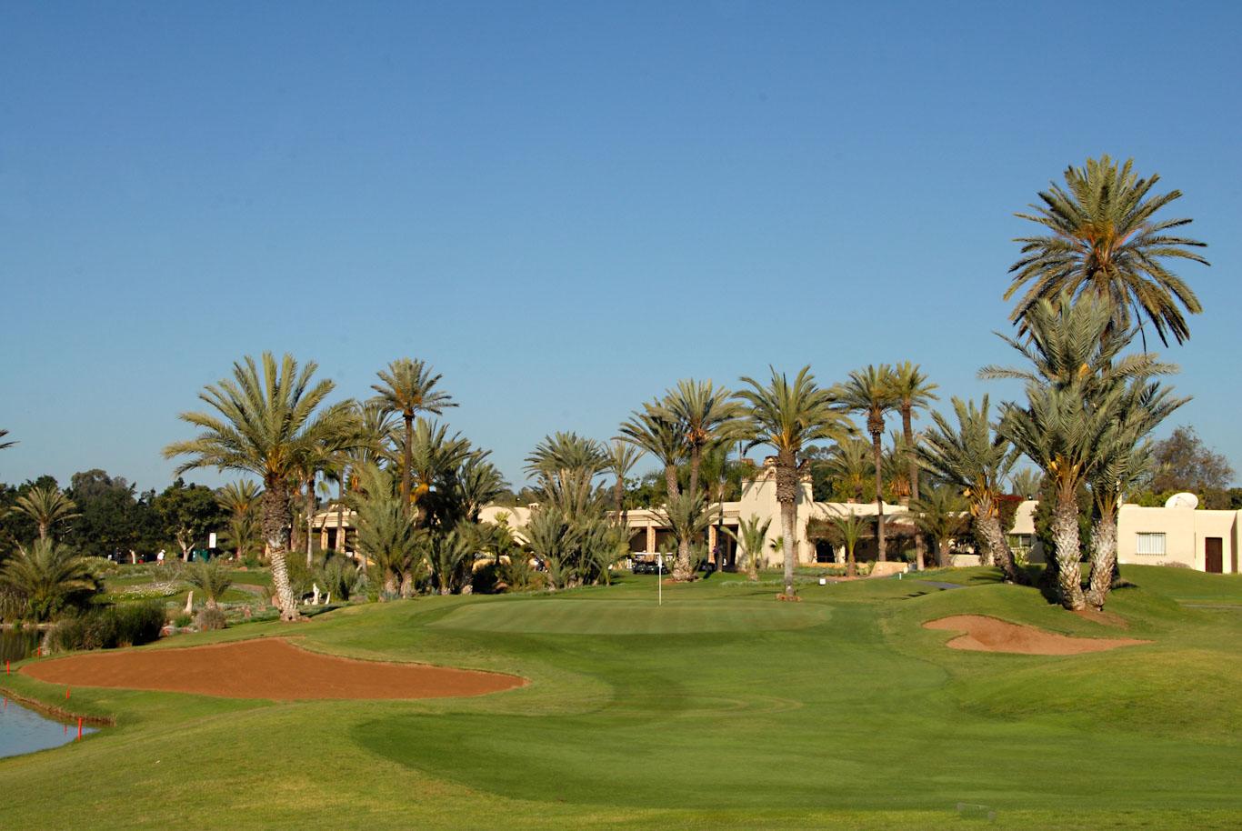 A well maintained fairway nestled with sand bunkers and palm trees