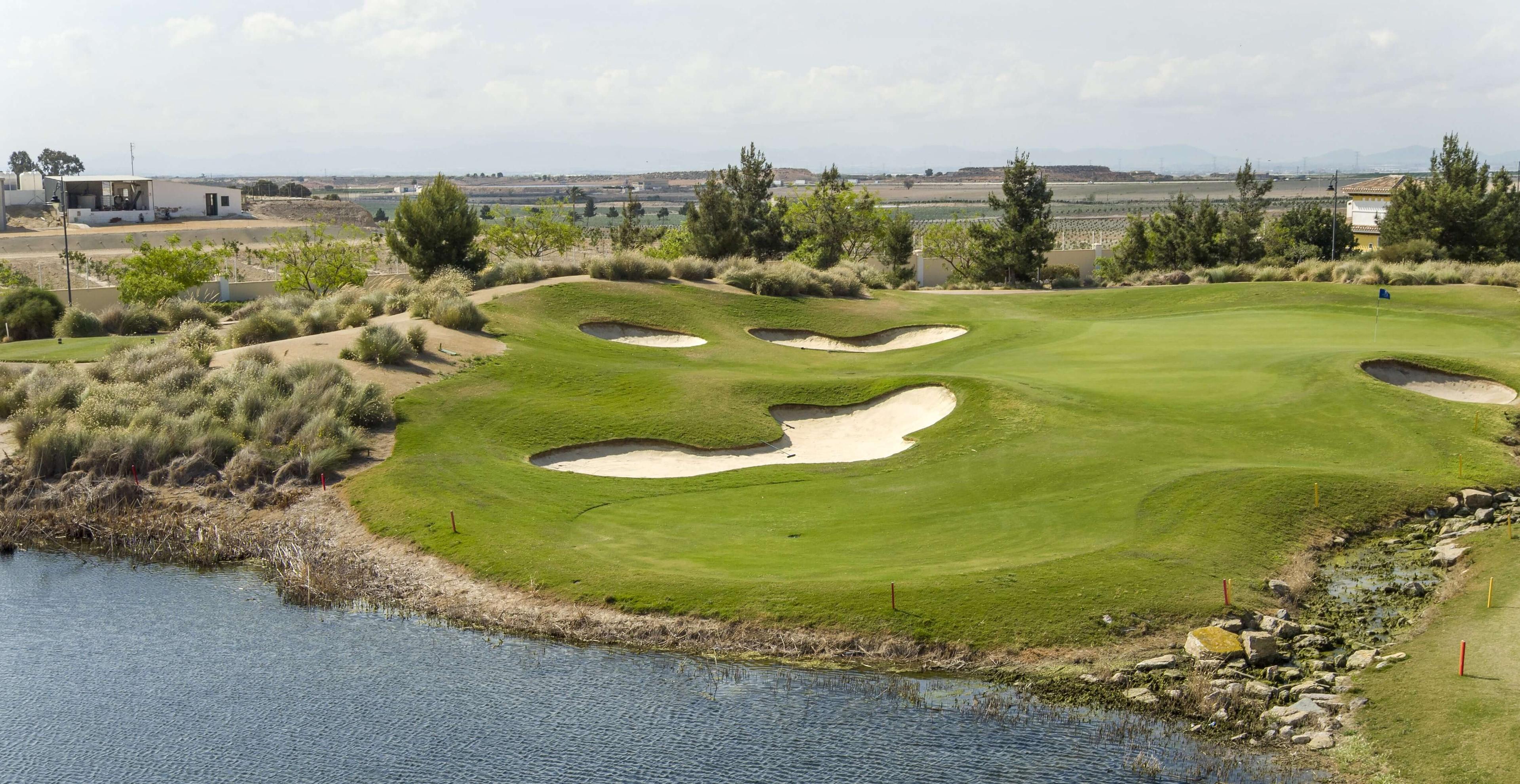 Undulating fairway leading to the green with water hazard in front