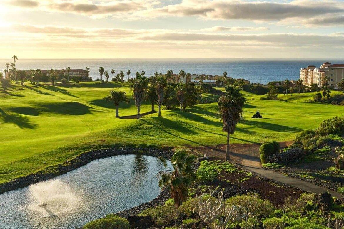 Sun shining over well maintained fairways with coastal views