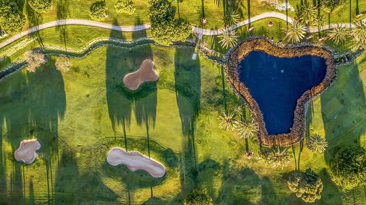 Aerial view of a smooth green surrounded by sand bunkers