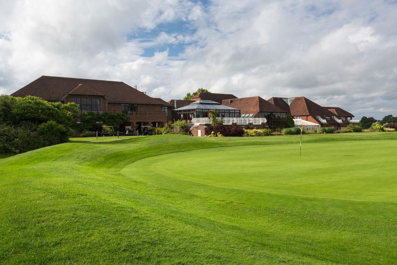 Smooth, manicured green with the clubhouse and resort in the background