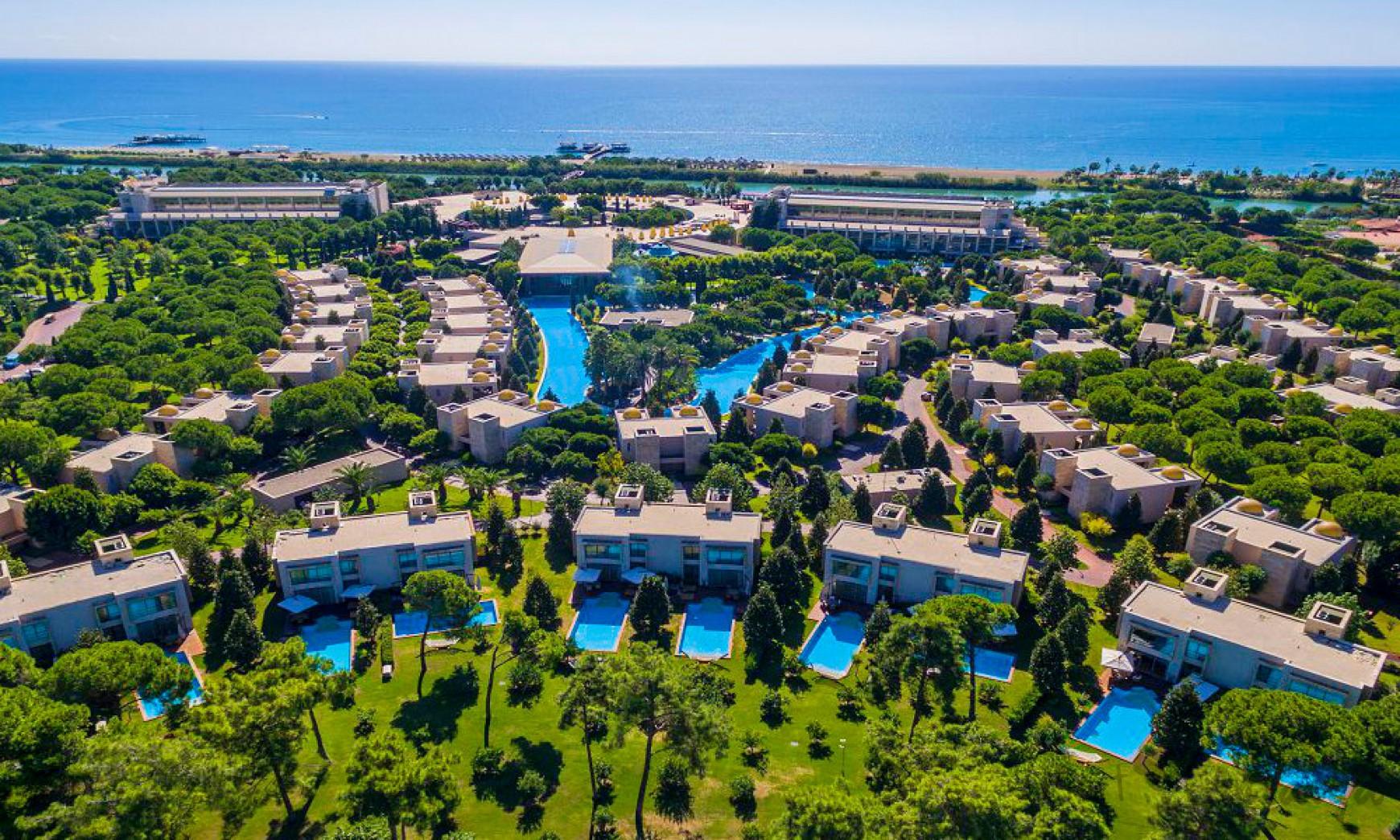 Aerial view of the private villas at the resort with the beach in the background