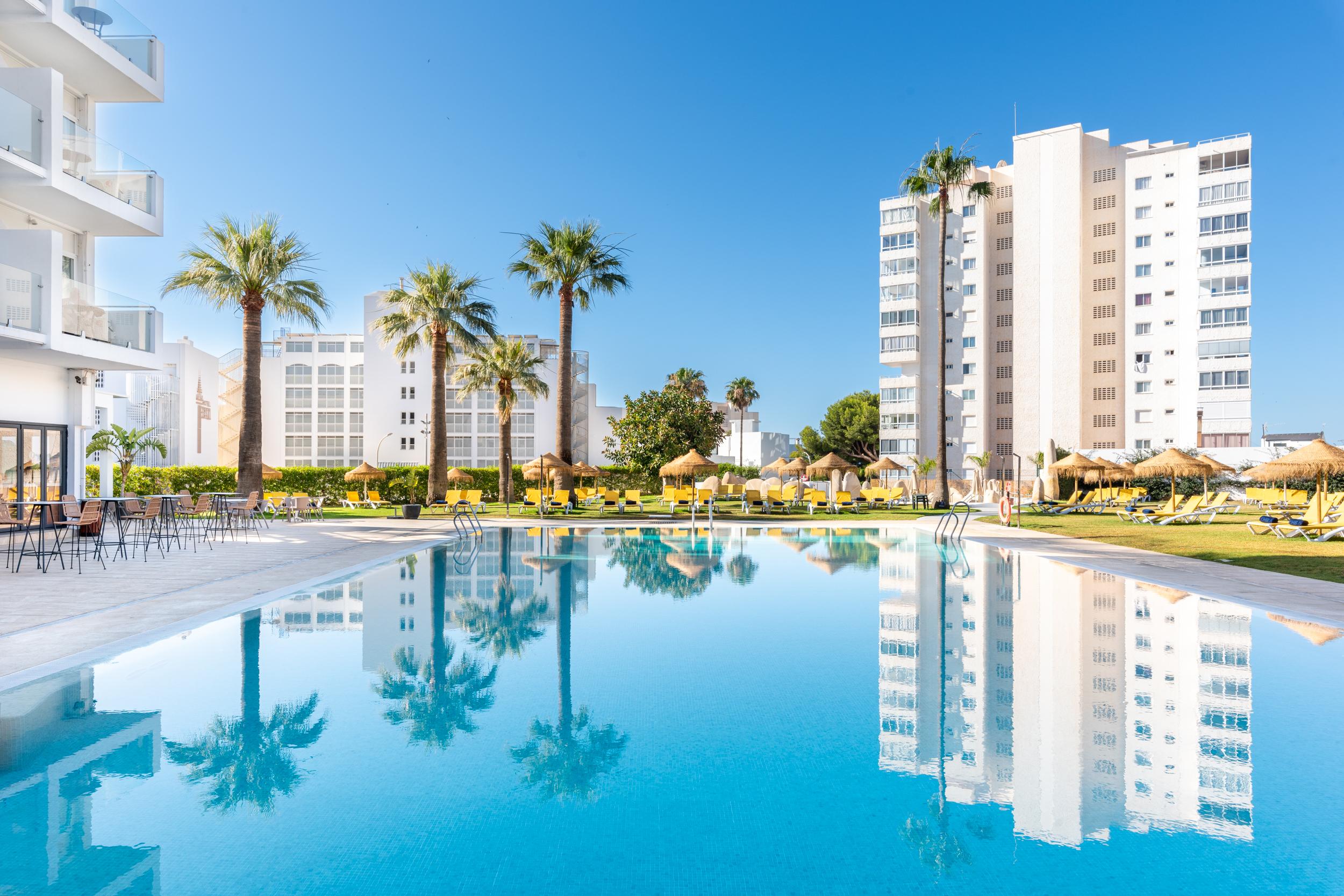 Outdoor swimming pool at Hotel THB San Fermín surrounded by palm trees