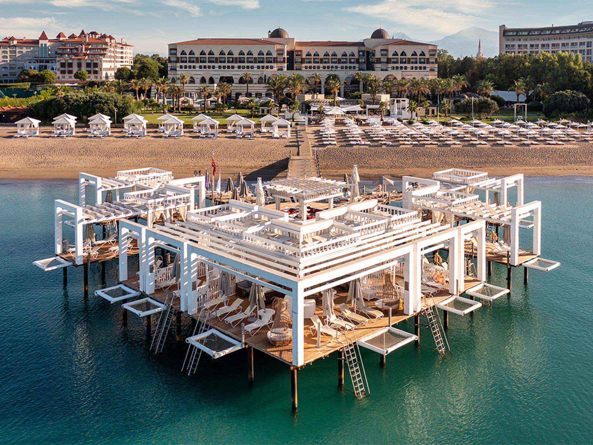 Aerial view of the beach with a pier with sun loungers on it