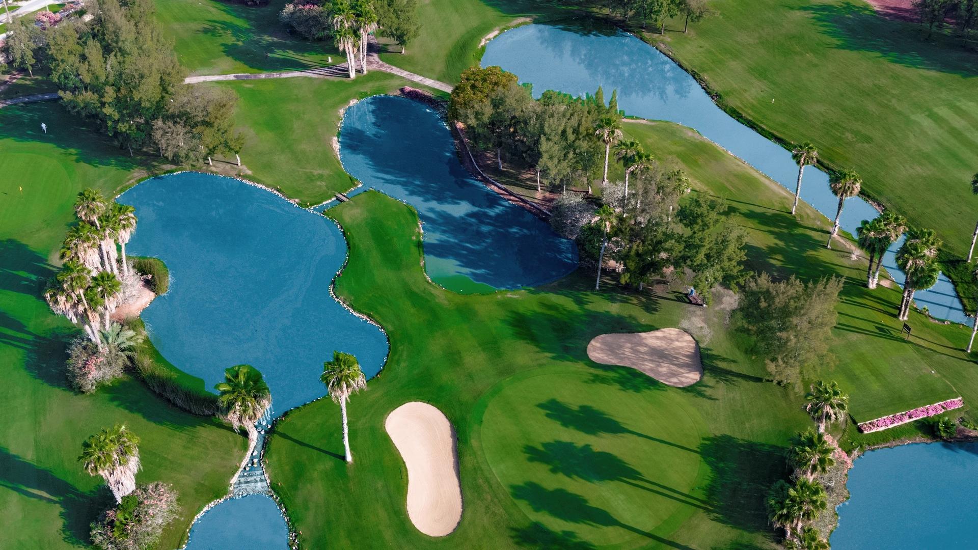A well maintained fairway nestled with sand bunkers