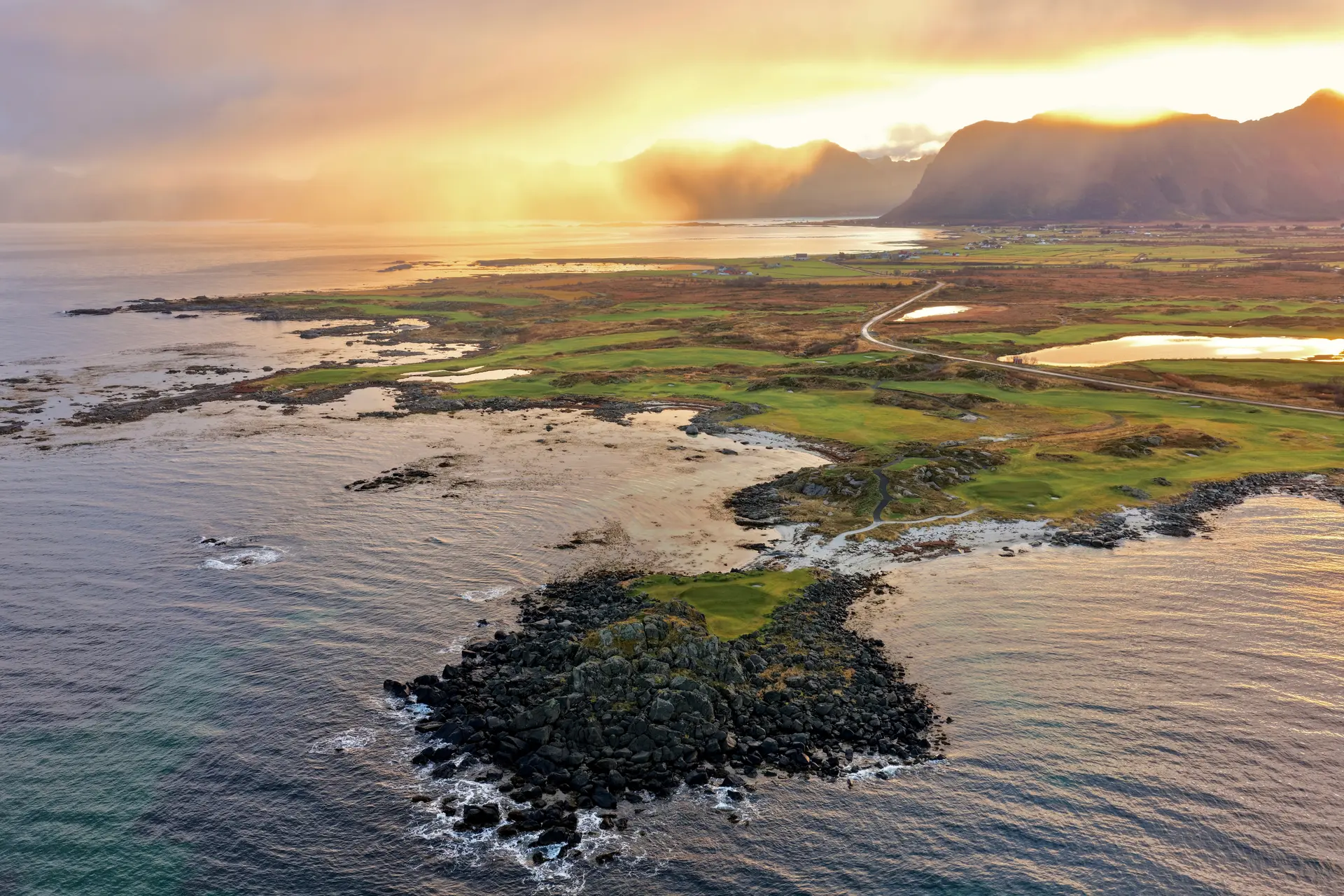 Overhead view of the sun setting in the distance over the Lofoten Links course