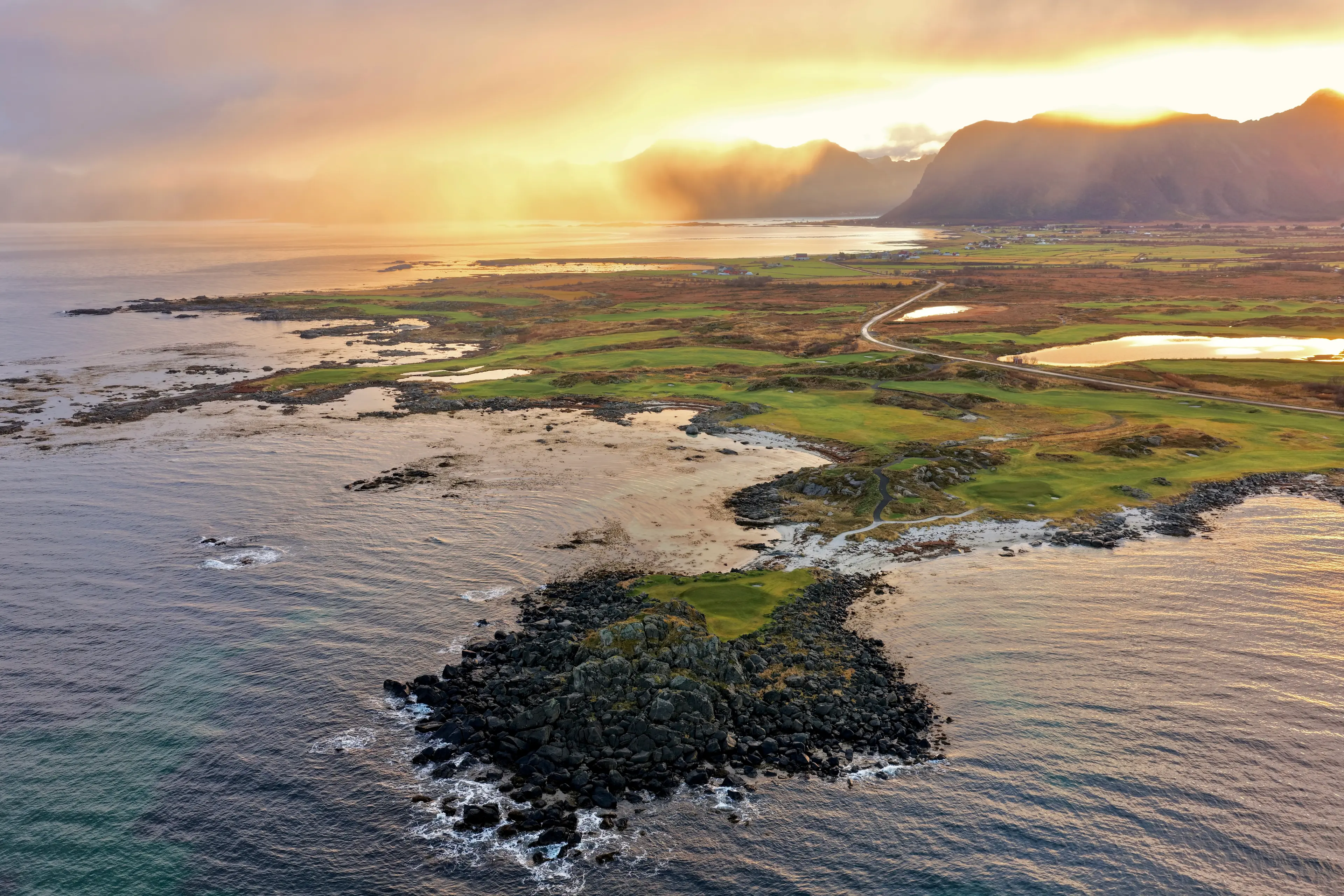 Overhead view of the sun setting in the distance over the Lofoten Links course