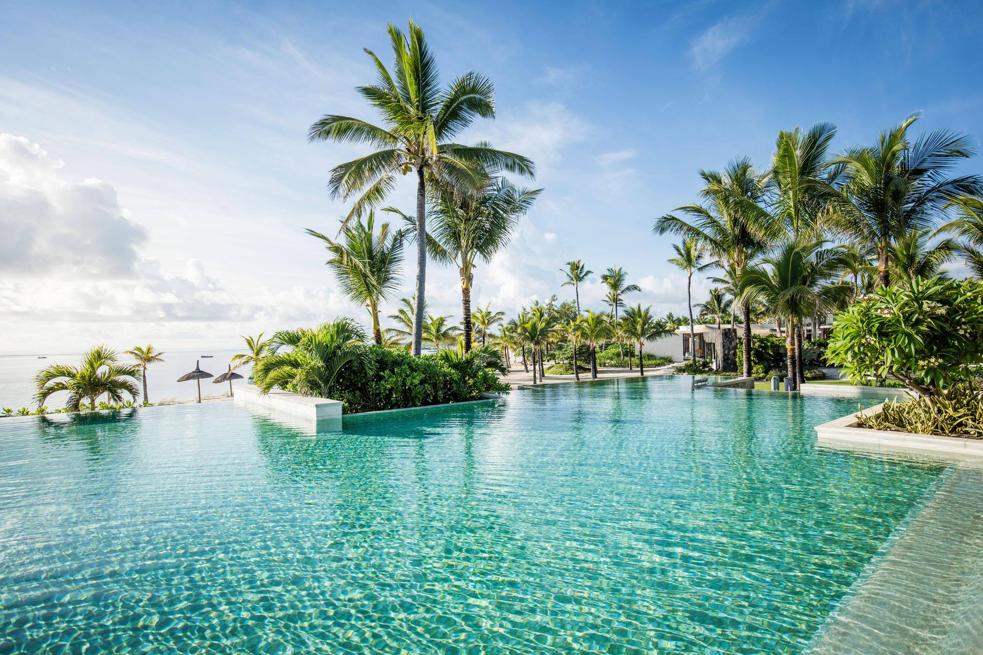 Outdoor swimming pool with palm trees at Long Beach Mauritius