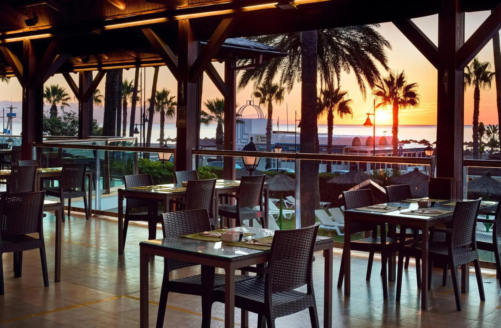 Outdoor dining area with the sun setting in the distance at Melia Sol Principe