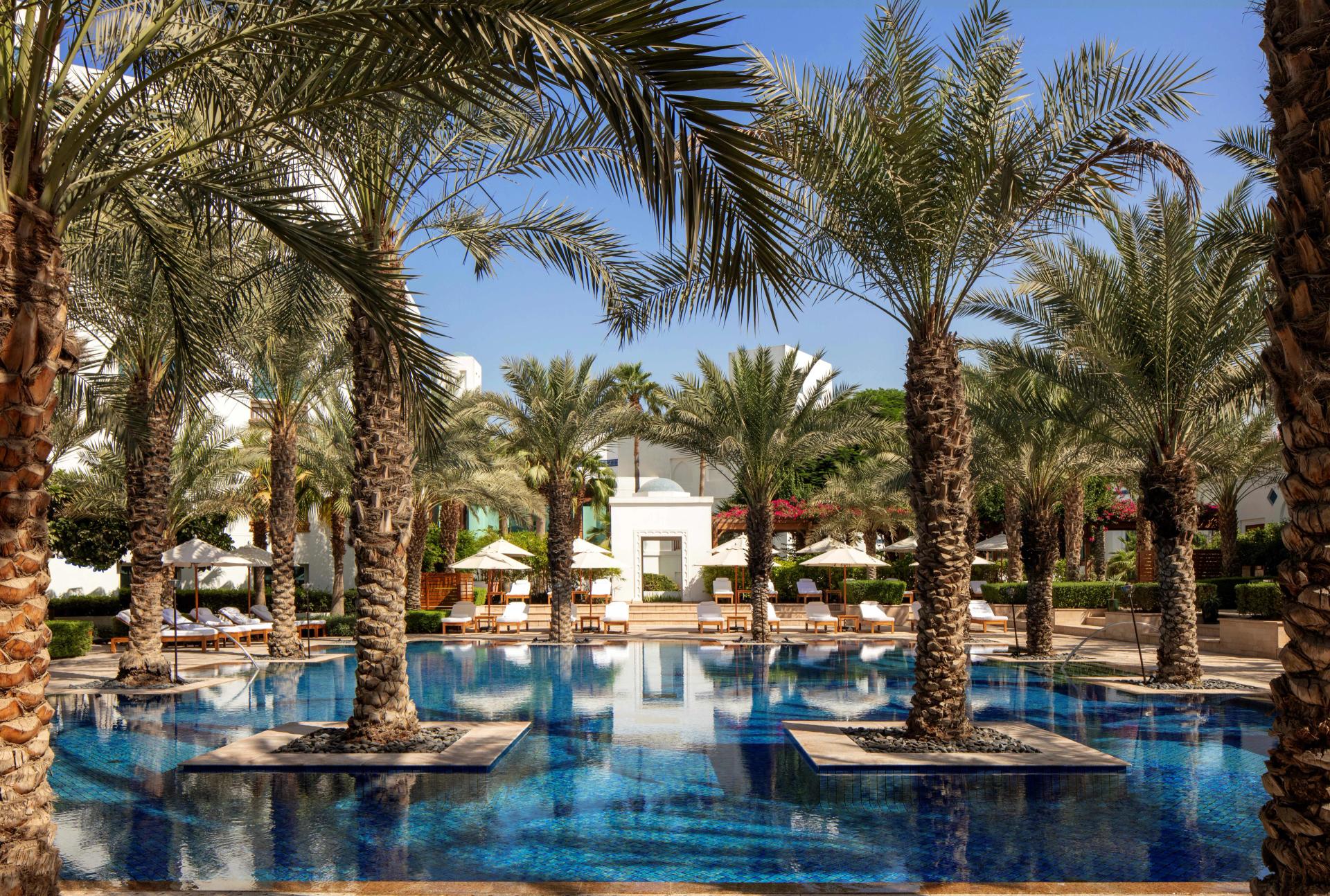 Outdoor swimming pool with palm trees at the Park Hyatt Dubai Creek