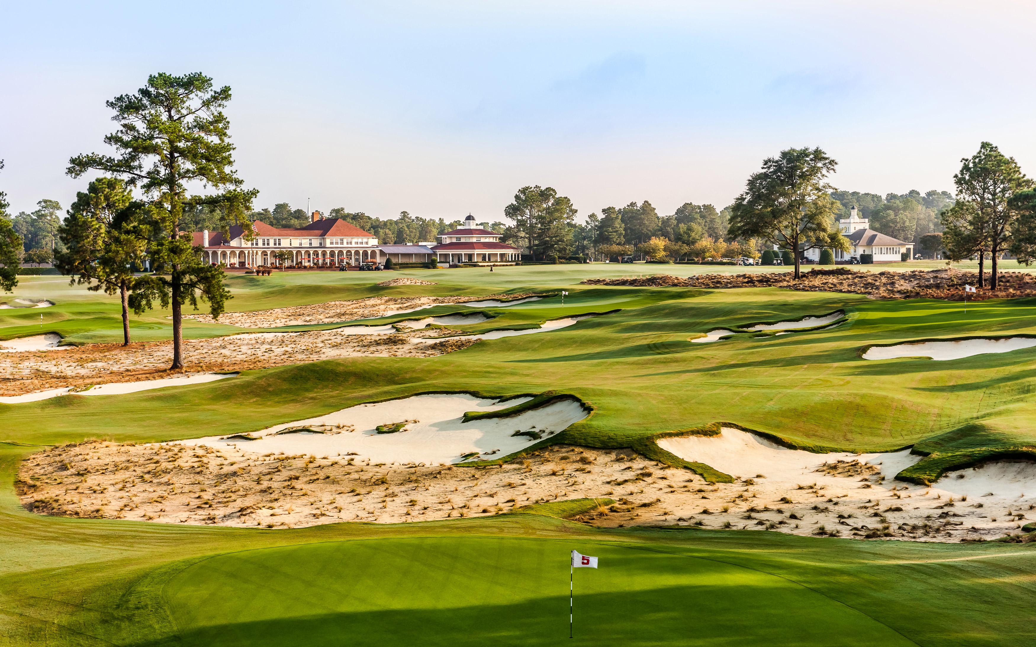 A well maintained fairway nestled with sand bunkers