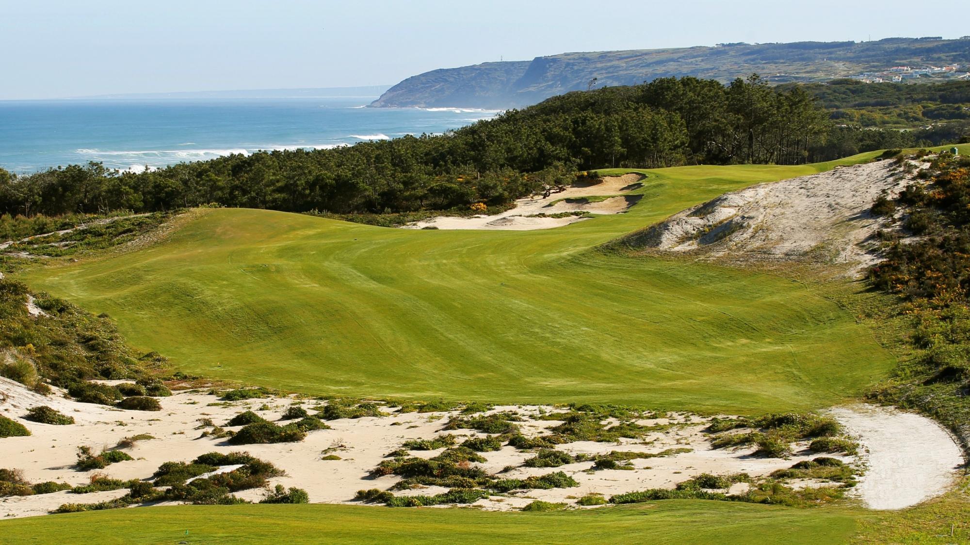 A well maintained fairway surrounded by a sandy rough
