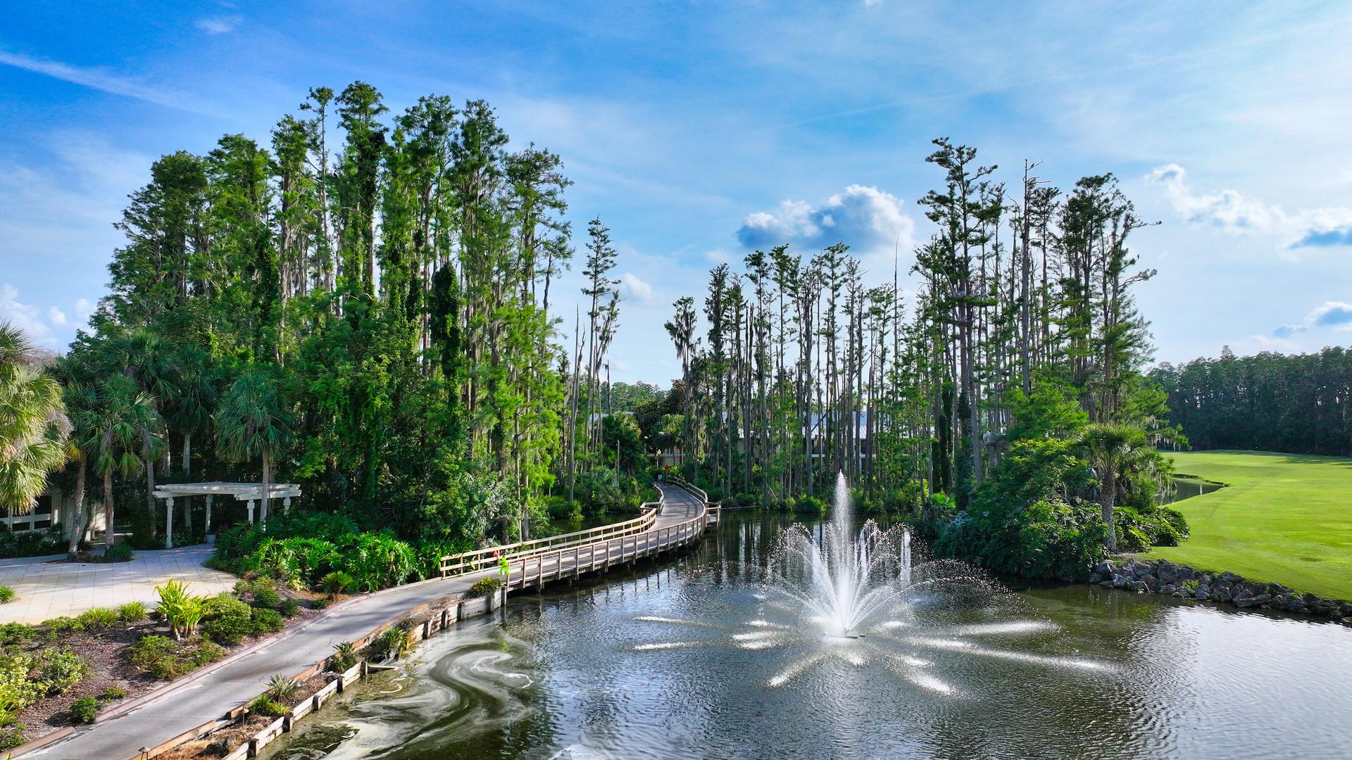Panoramic view of a water hazard with a fountain and bridge to navigate the course