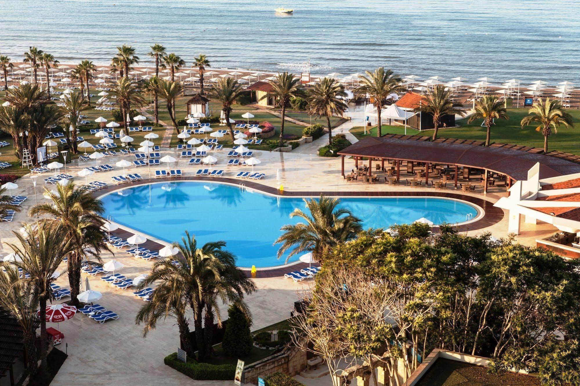 Aerial view of the outdoor pool area with the sea in the background