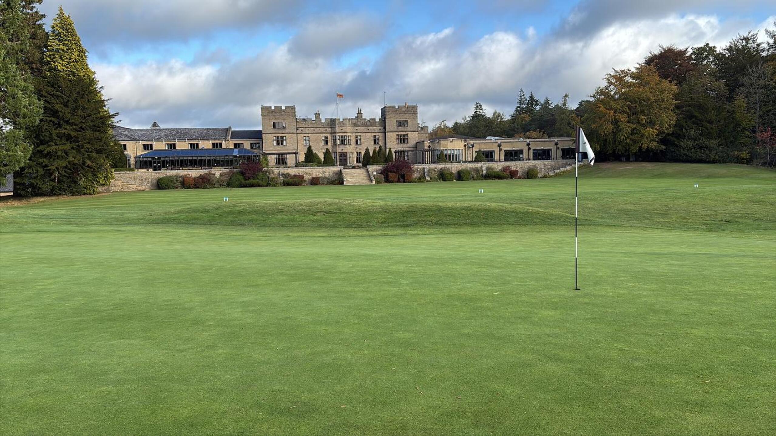 Smooth, manicured green with the clubhouse and hotel in the background