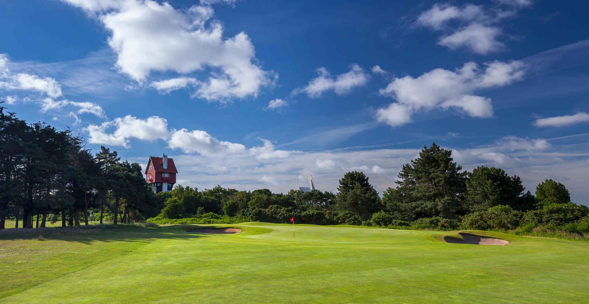 Panoramic view of a manicured green under blue skies