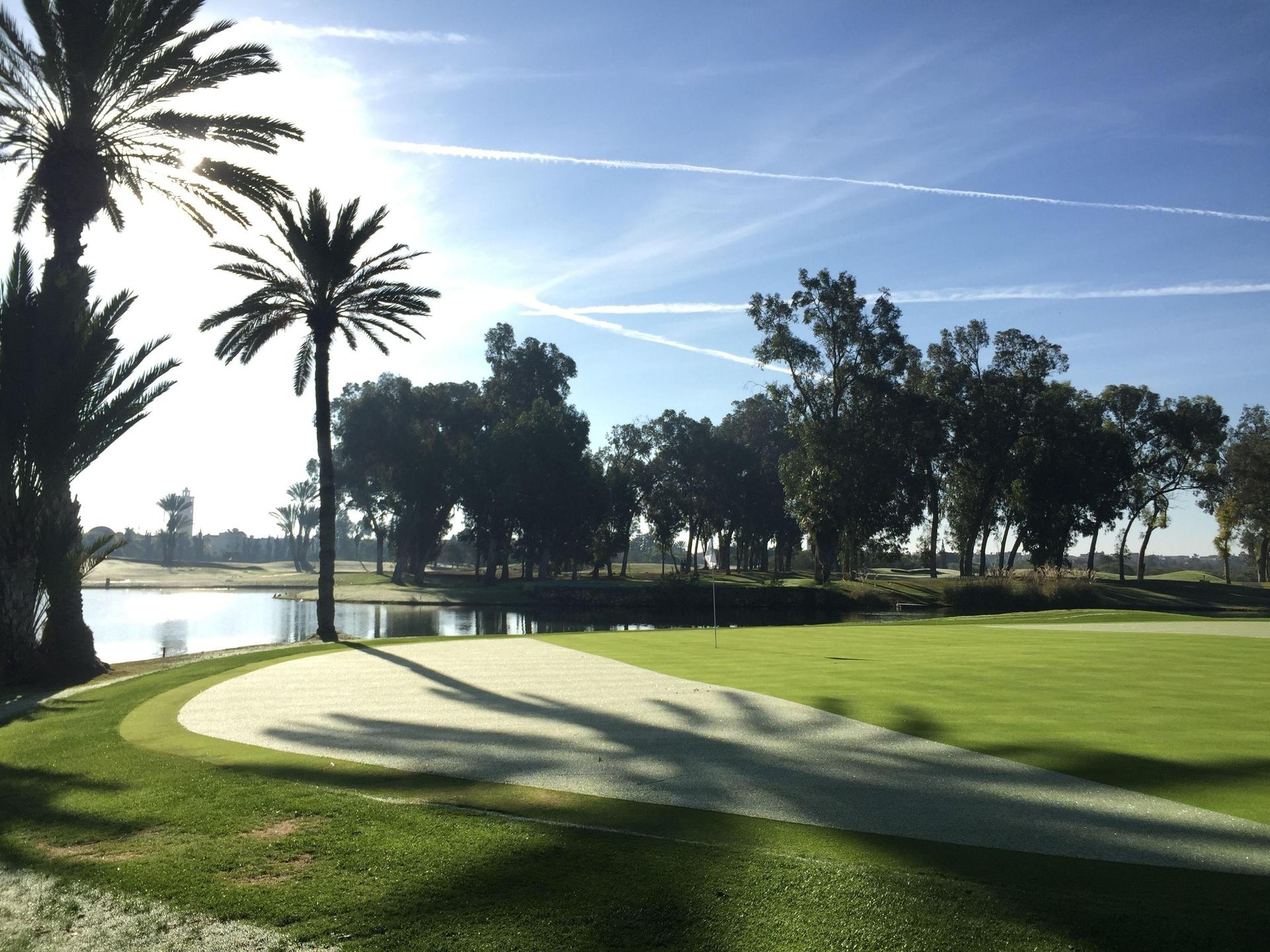 A well maintained fairway next to a water hazard at Tikida Golf Palace