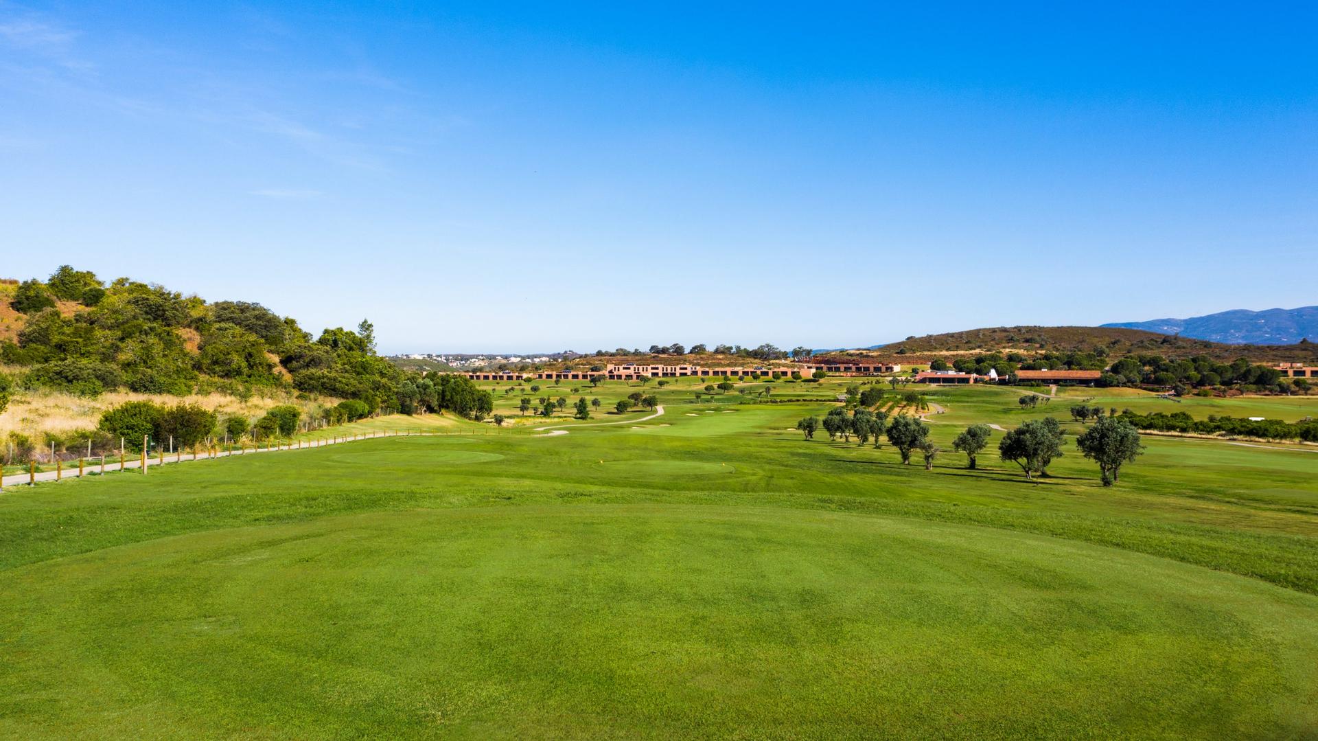 A well maintained fairway under clear blue skies