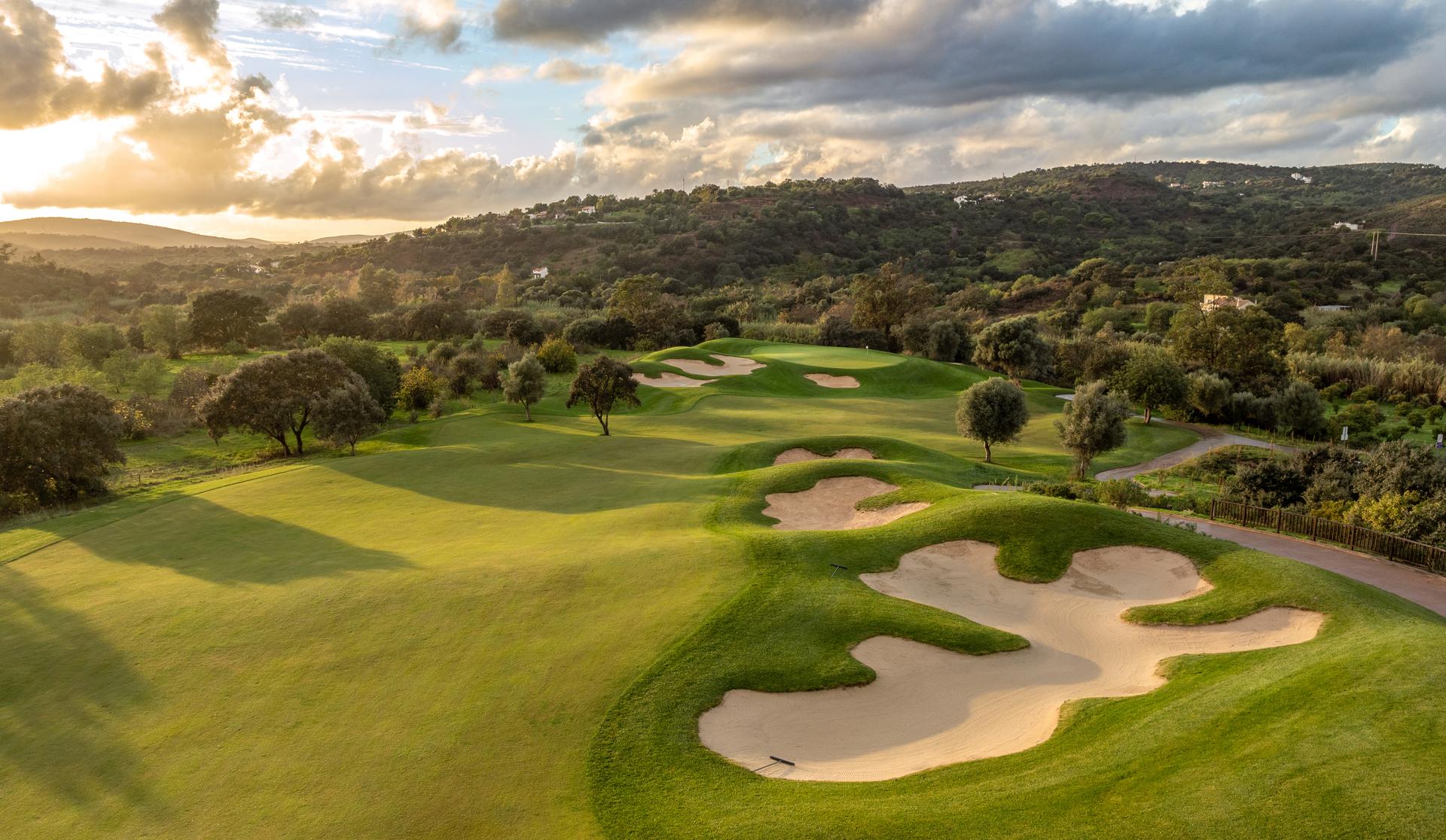A well maintained fairway nestled with sand bunkers