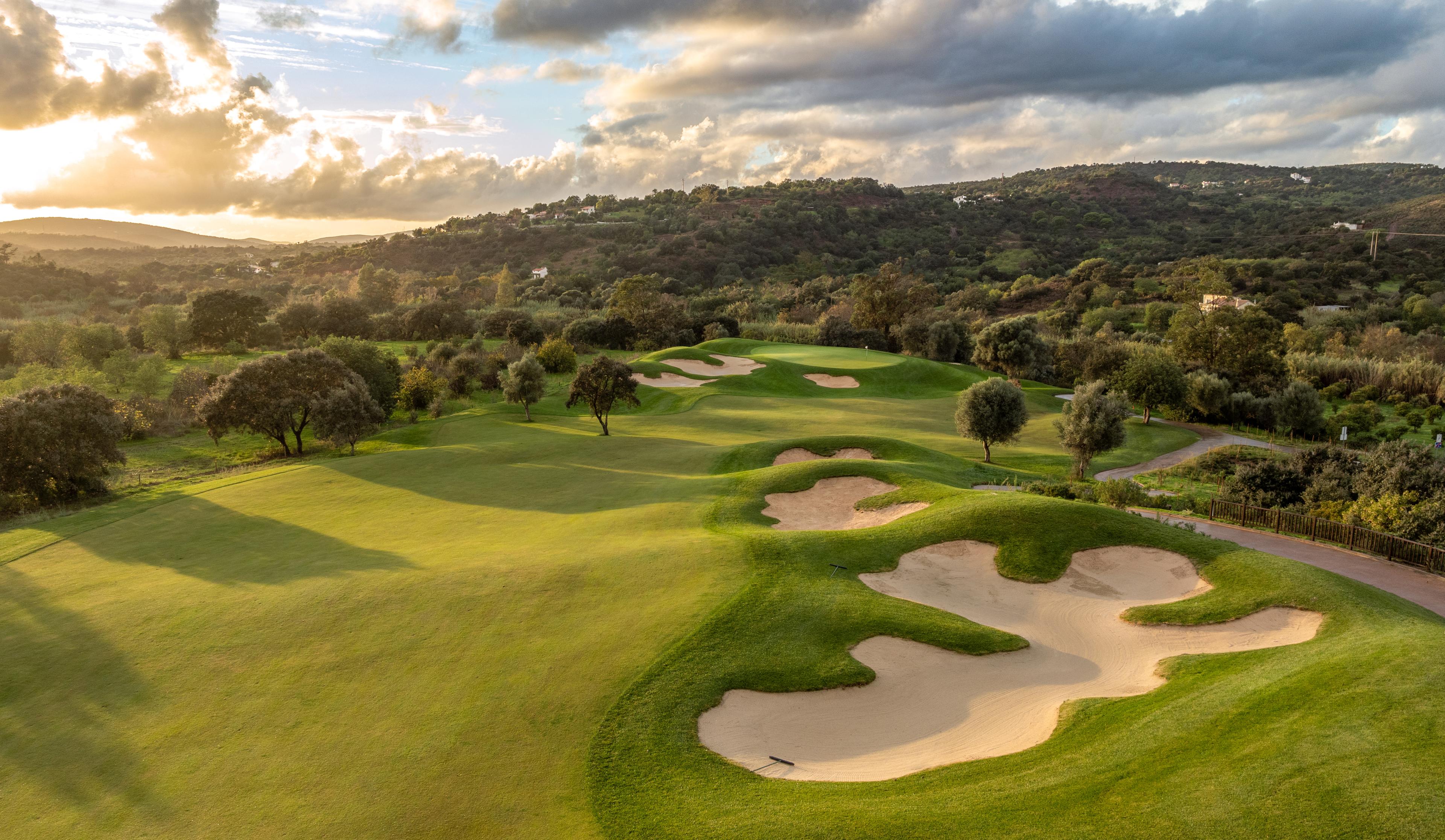 A well maintained fairway nestled with sand bunkers