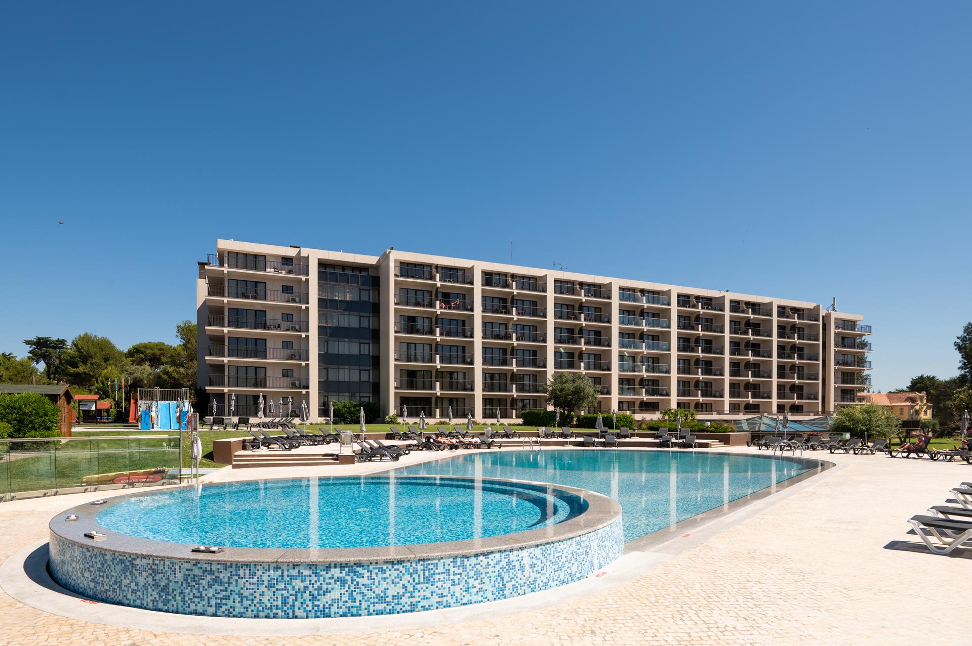 Outdoor swimming pool with the hotel building in the background