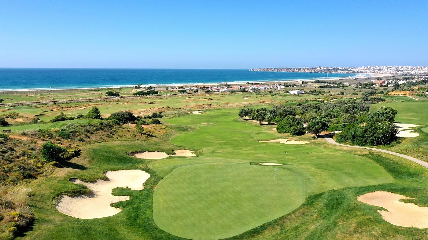 A well maintained green surrounded by sand bunkers