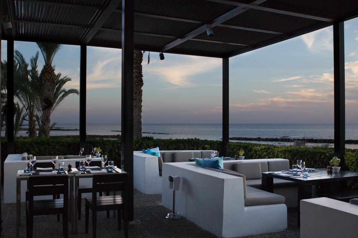 Outdoor dining area with a lounging space at Almyra Hotel